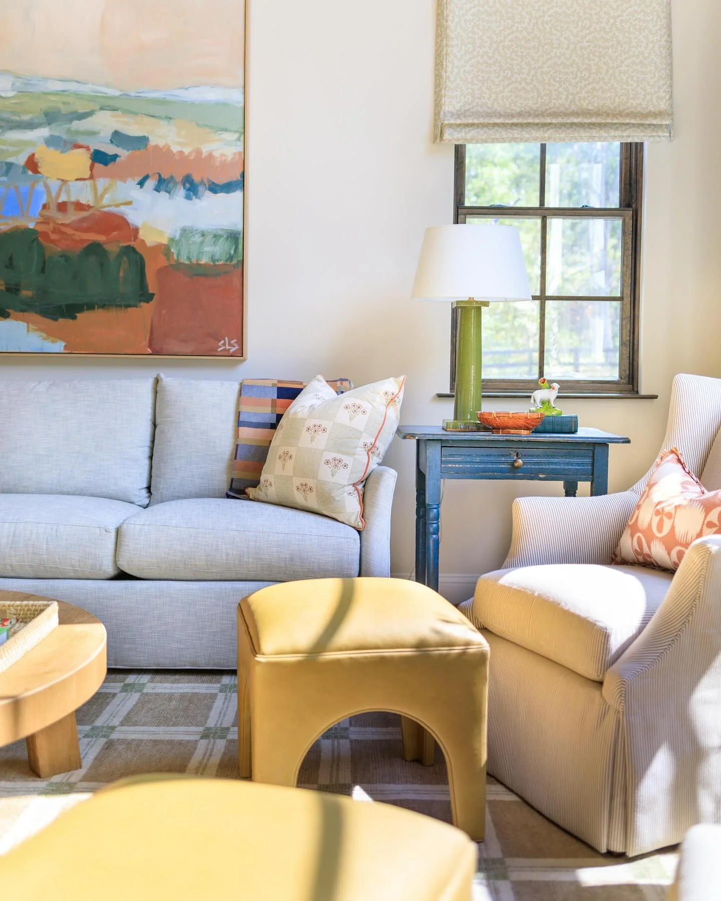 The goal for this decorating project was to make a grand somewhat modern space feel cozy, traditional and approachable. Art, textiles and lots of warm color did the trick in transforming this space that now it feels like a great place to spend a fall