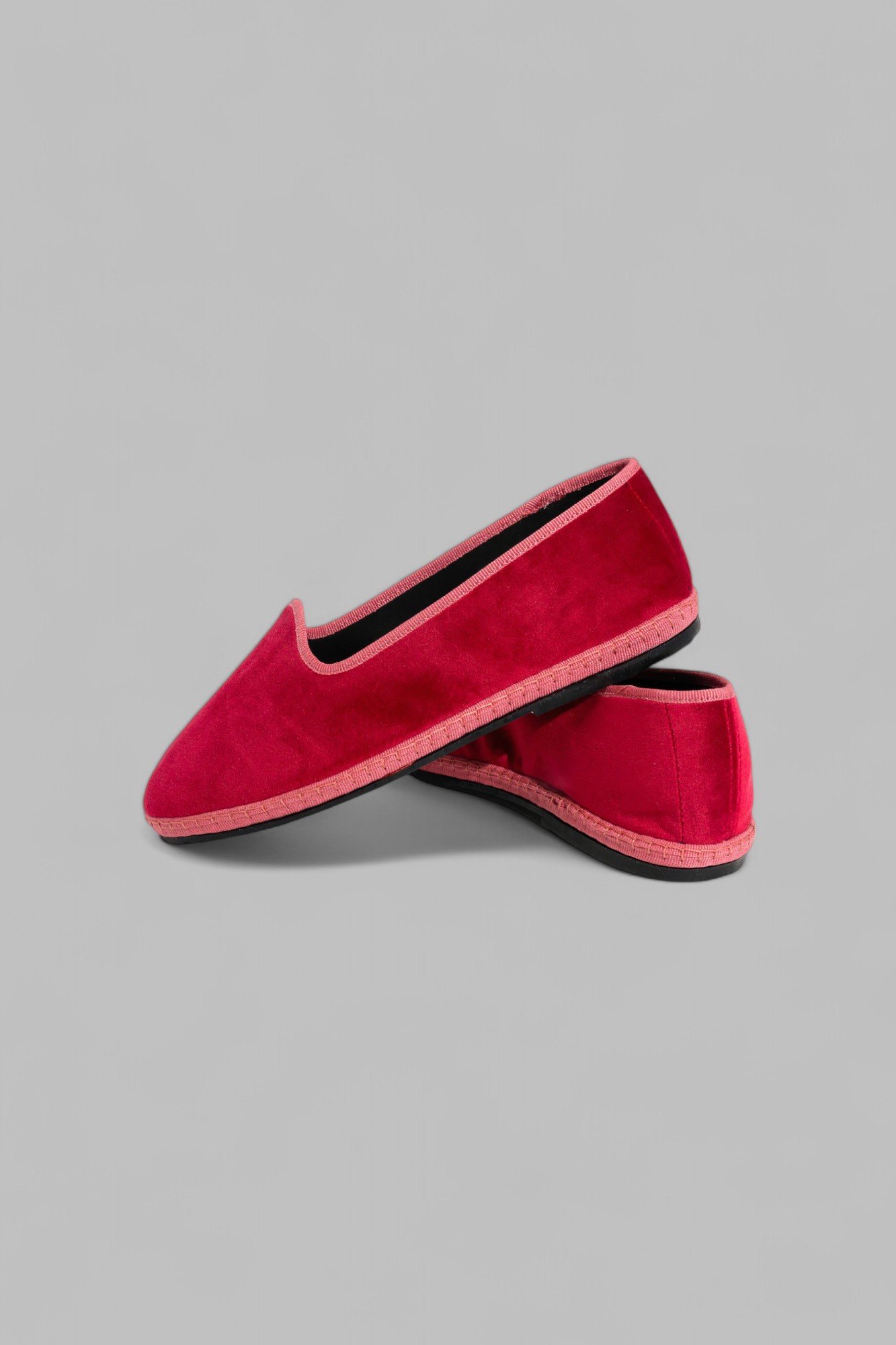 Pair of rose velvet Gioia slippers overlapped, one resting on top