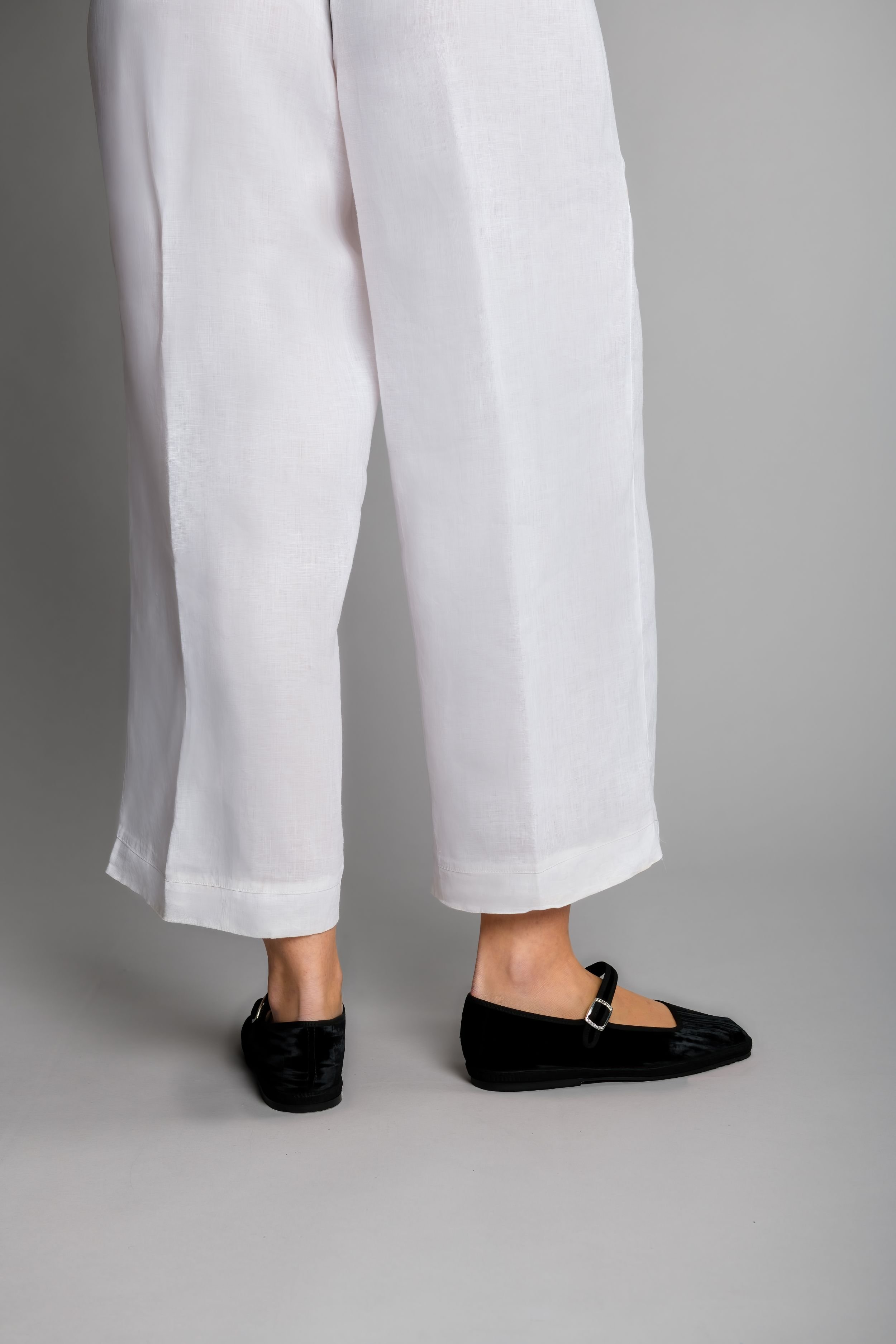 Rear view of model in black textured velvet Mary Janes, standing tall