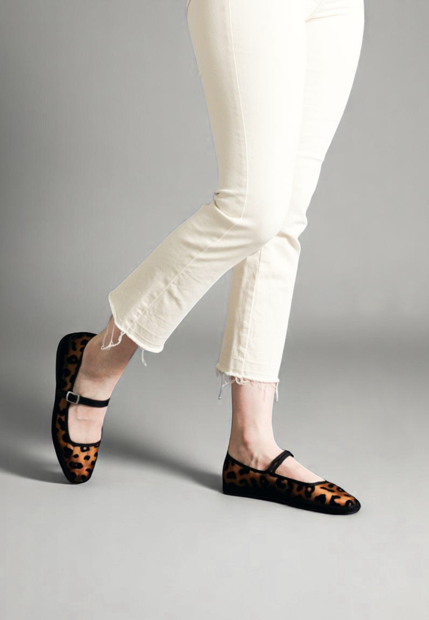 Striding wearing Aria flats in fashionable cheetah print in black mesh - the wildest walk in the room