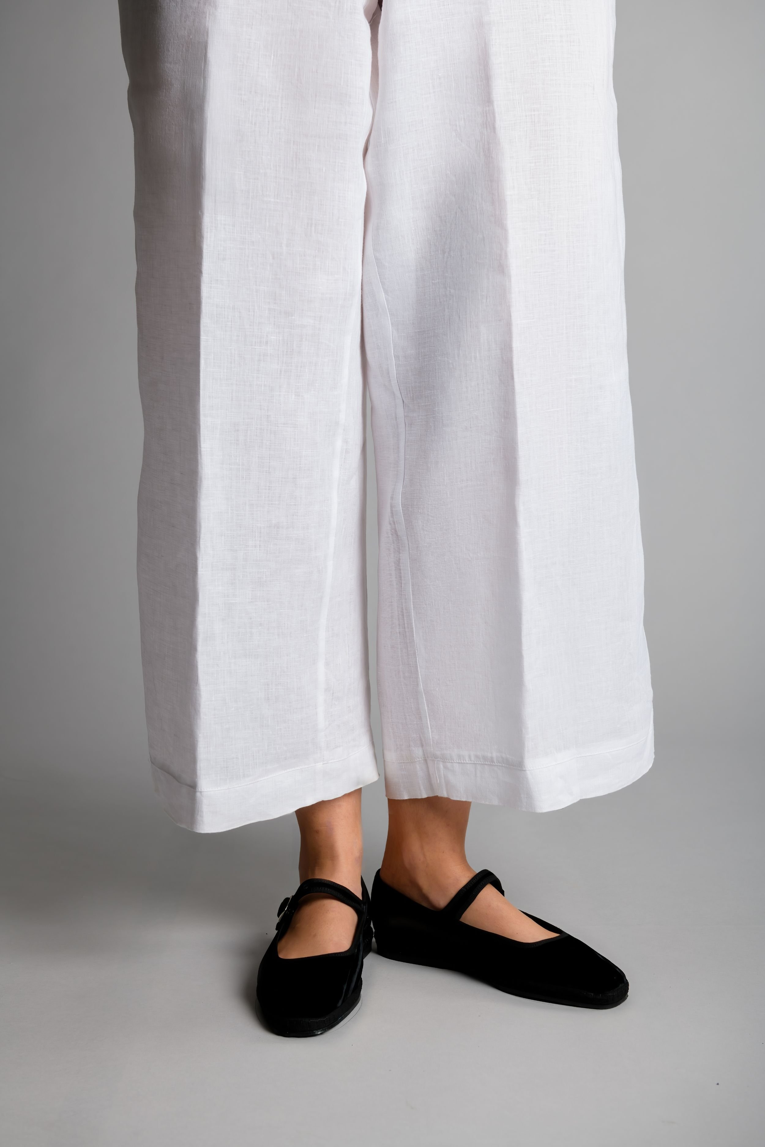 Front view of model wearing Mary Jane flats with white linen pants