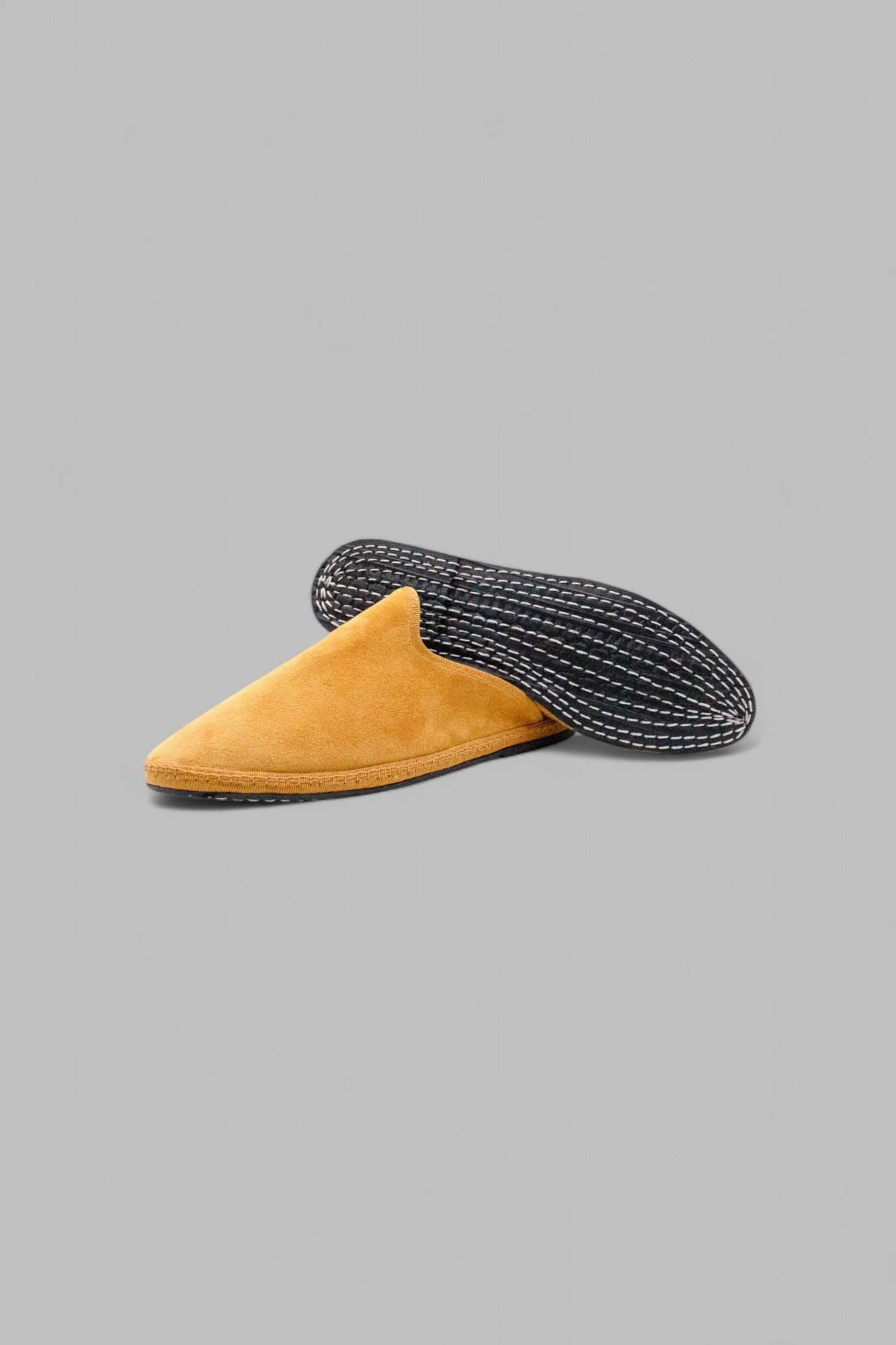 Underside of Solea velvet mule showing hand-stitched rubber sole