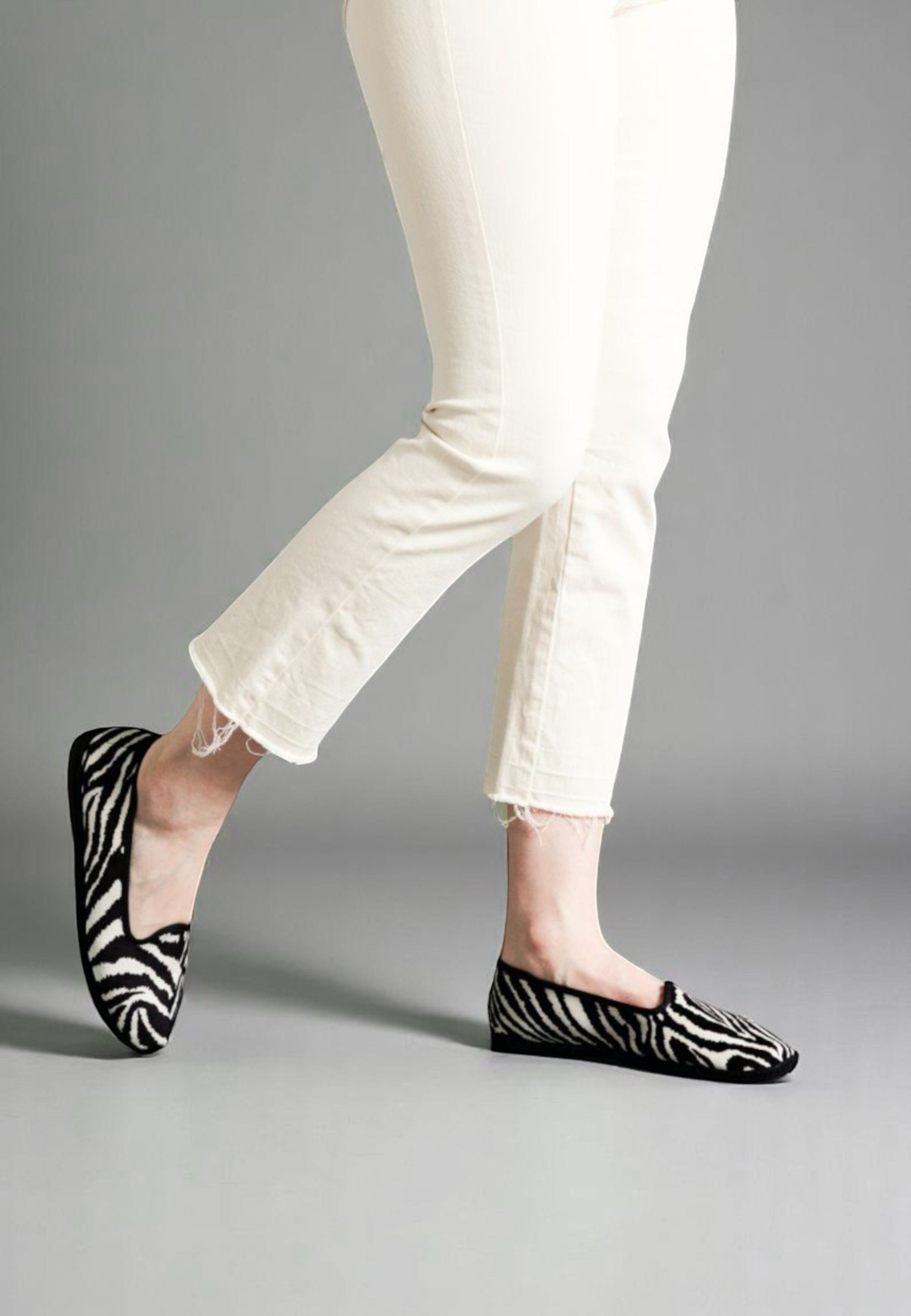 Walking view of Zebra Gioia slippers - print in motion, with minimalist denim, showing comfort and style merging together.