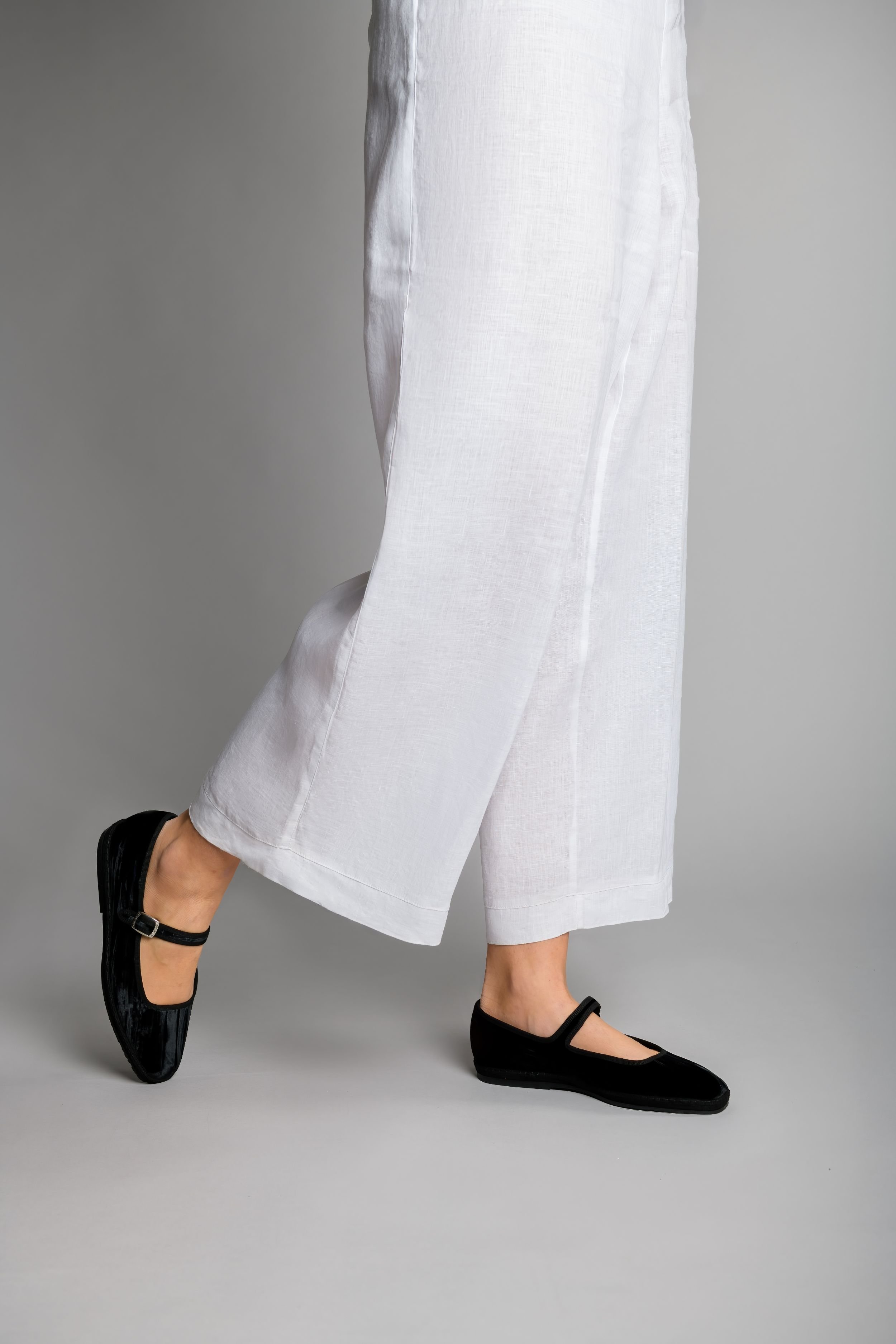Model walking in Eclipse Mary Janes, wide-leg pants mid-motion