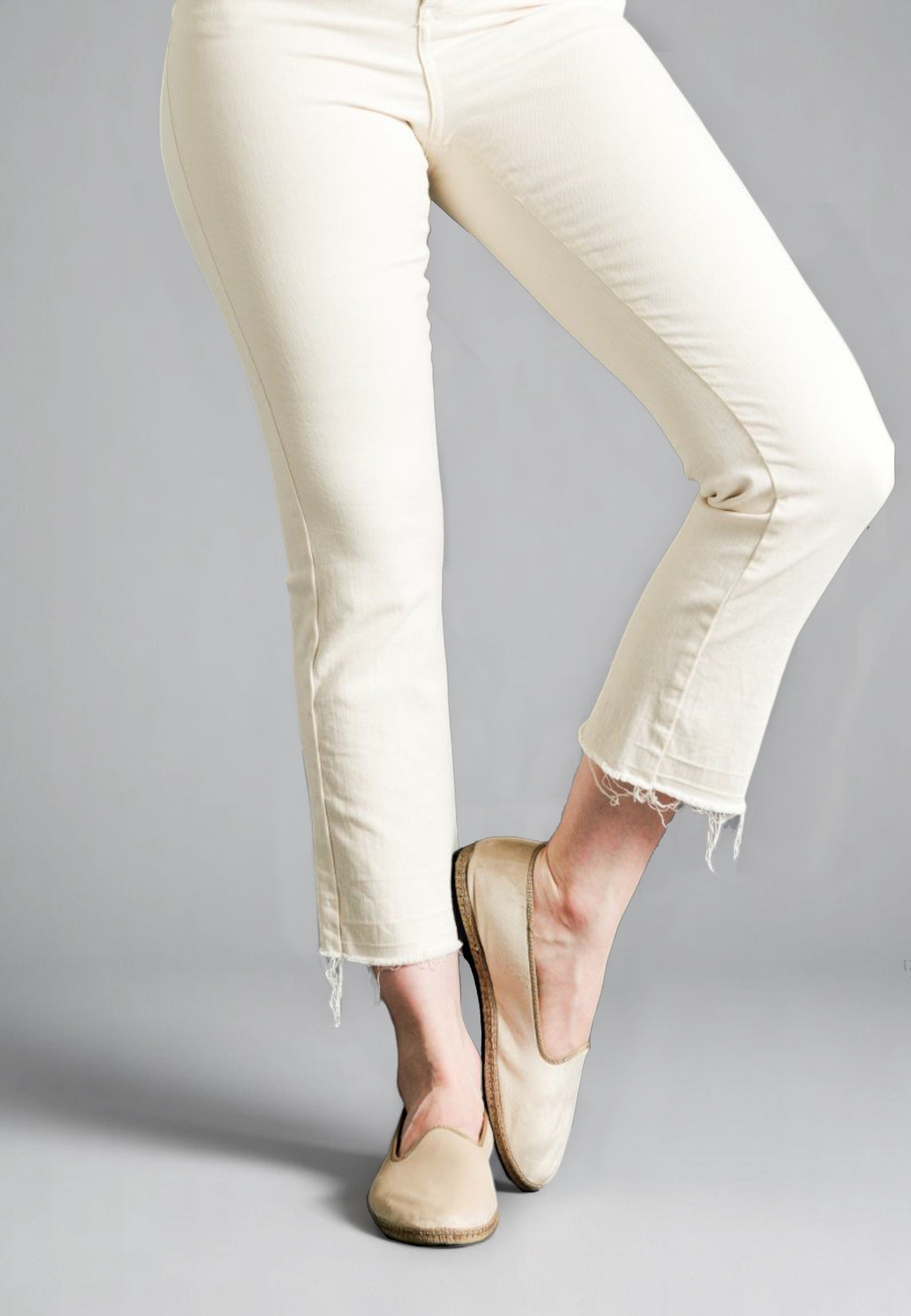 Lifted foot pose in soft Dunes Gioia velvet slippers with raw-edge ivory denim