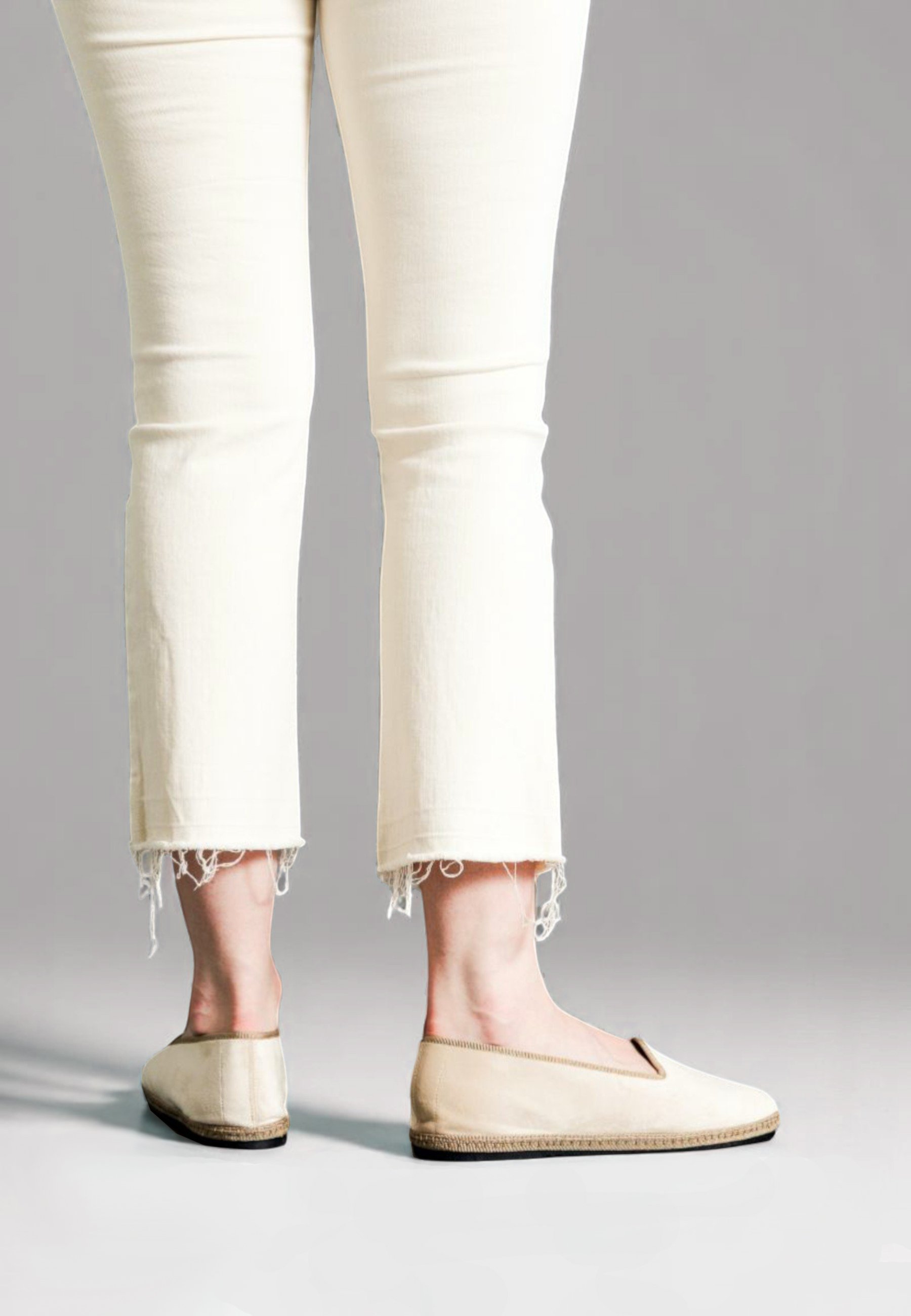 Rear view of model in italian handmade slippers Gioia, in minimal and neutral sand color