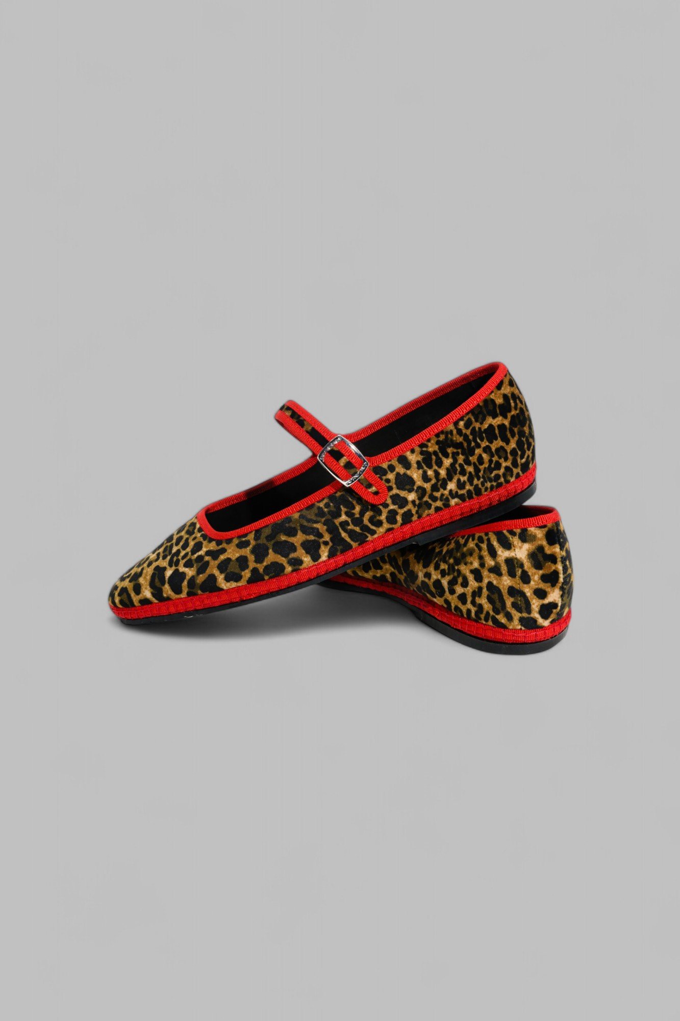 Pair of Jungle Mary Janes in leopard velvet with red piping, overlapped display