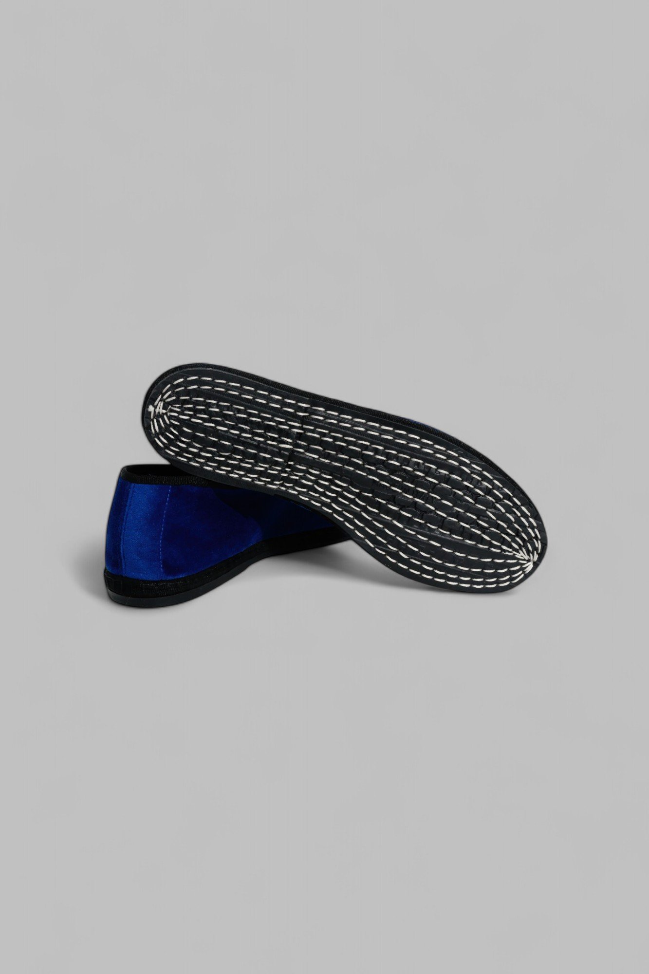 Bottom view of black recycled rubber sole with visible white stitching