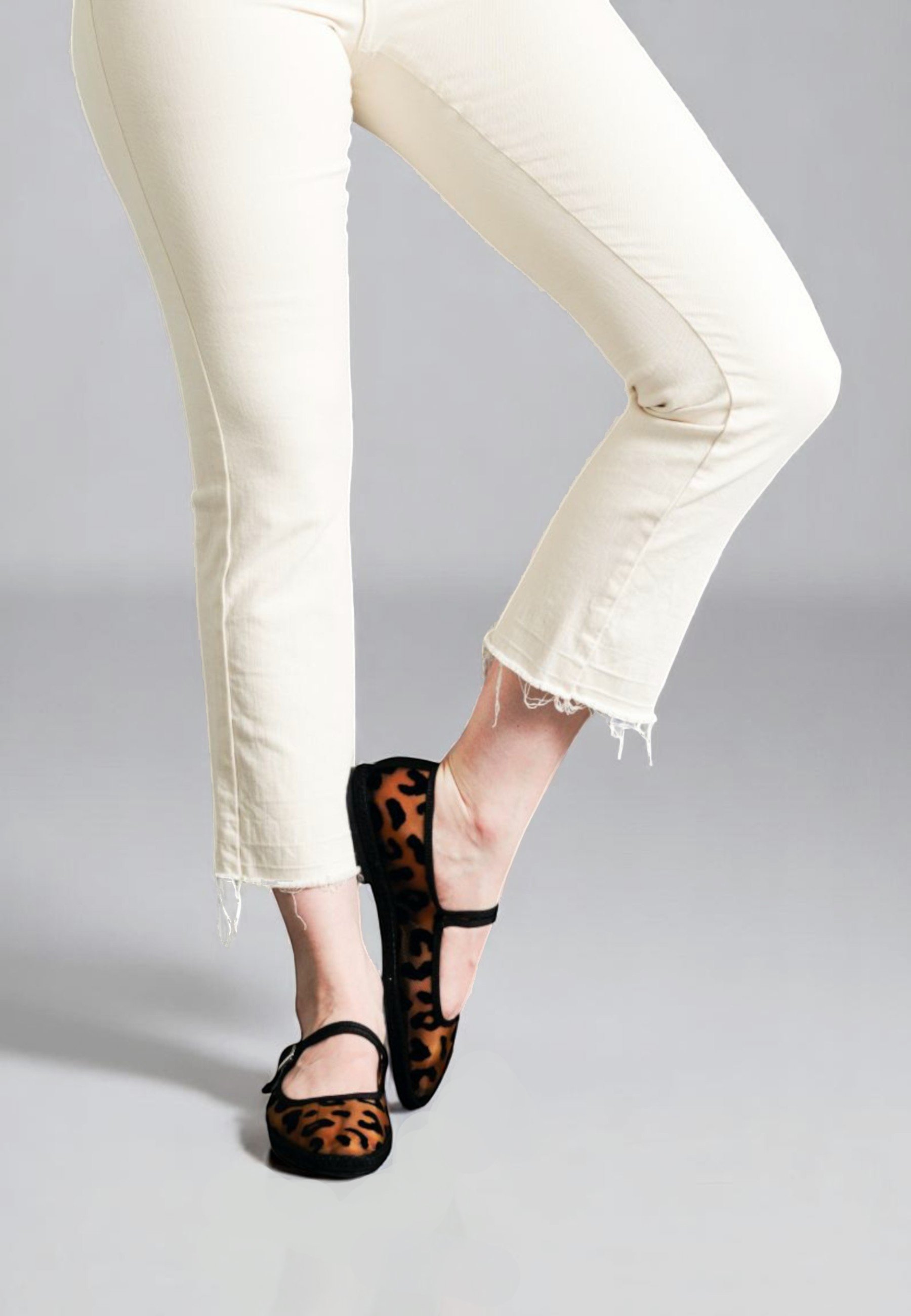 Raised foot pose in Aria Jaguar slippers, playful and fierce. Leopard pattern black mesh handmade italian Mary Janes.