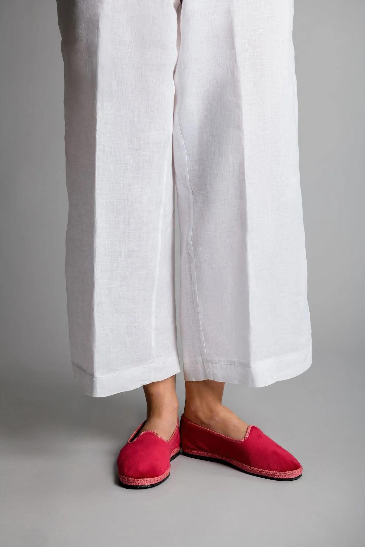 Front view of model wearing Gioia slippers with white linen pants