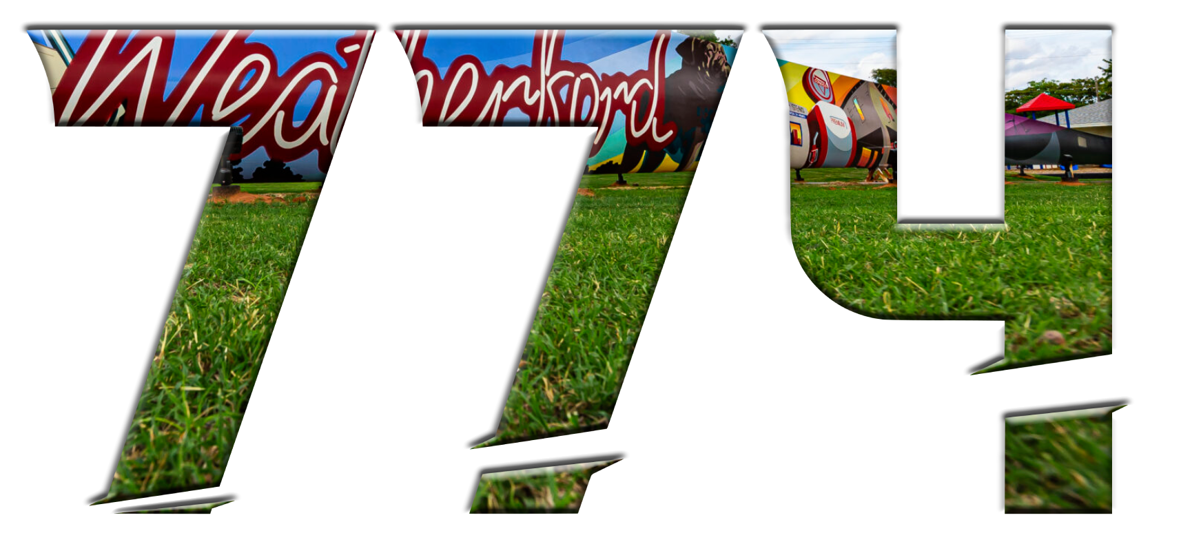 Text, "774" filled with colorful, graffiti-style art on a turbine blade, with green grass in the foreground and clear sky in the background.