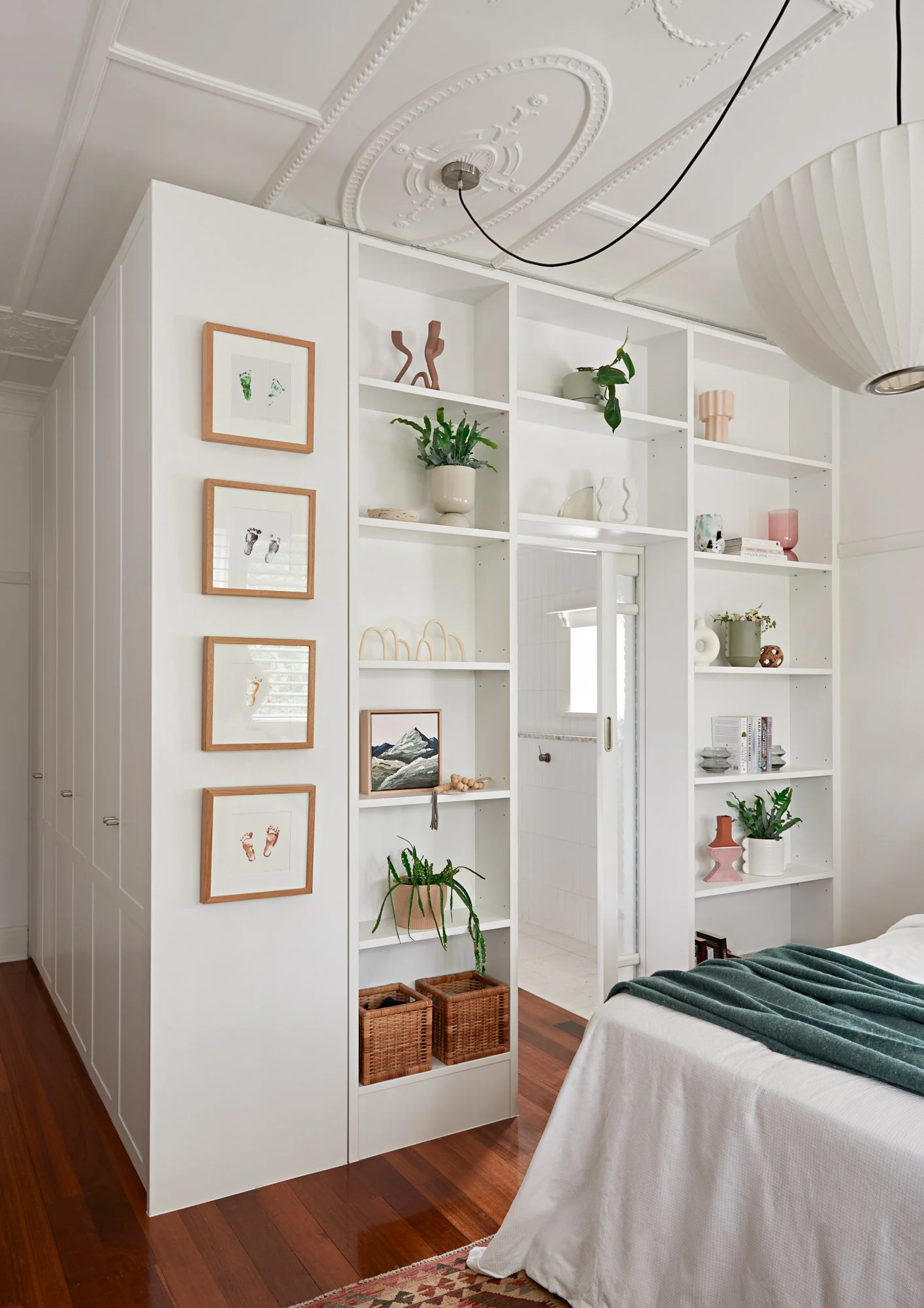 Custom floor-to-ceiling bedroom shelving and storage framing the entrance to the ensuite at Adella Court, Elwood.