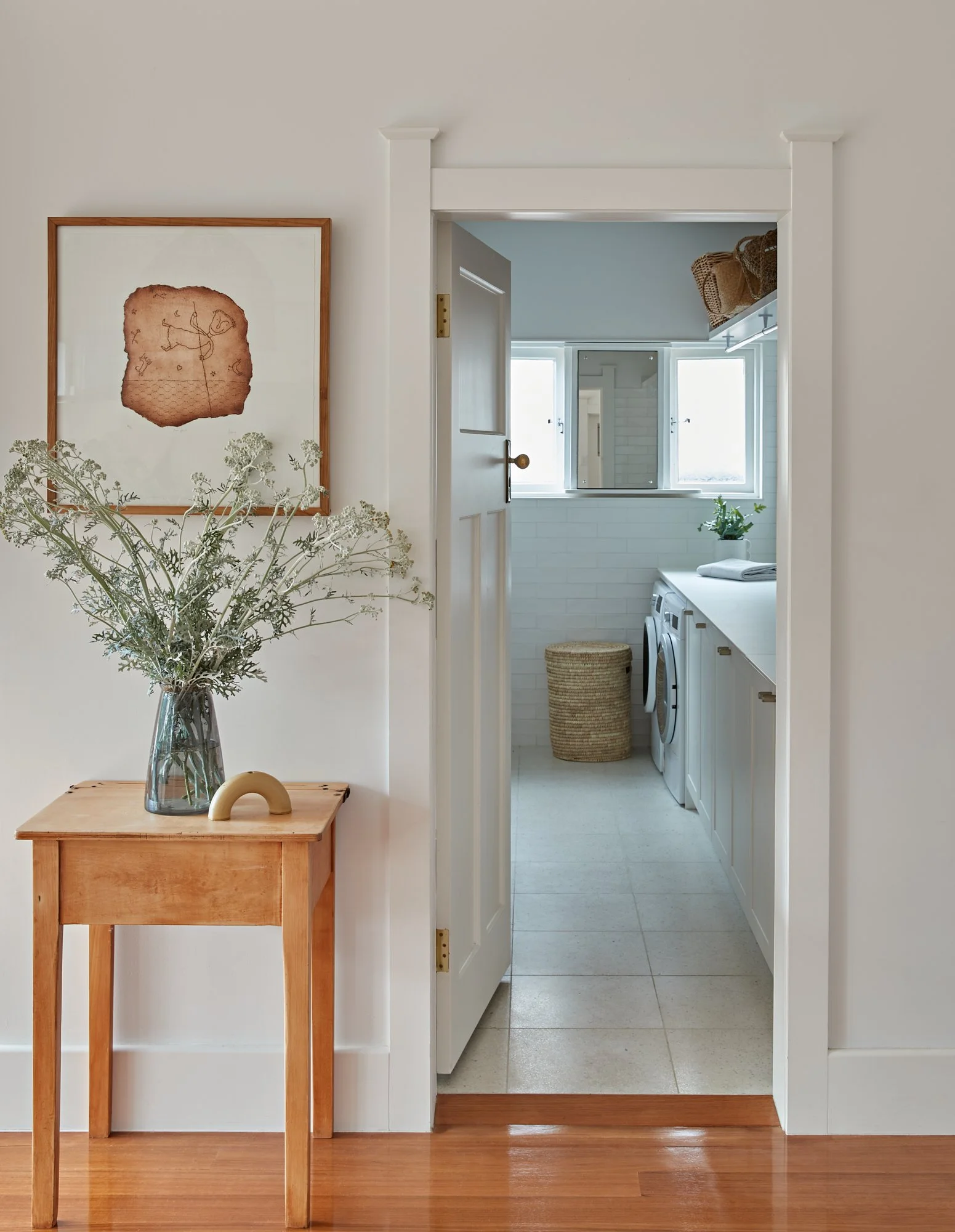 View from the renovated interior through to the laundry with white cabinetry at Adella Court, Elwood.