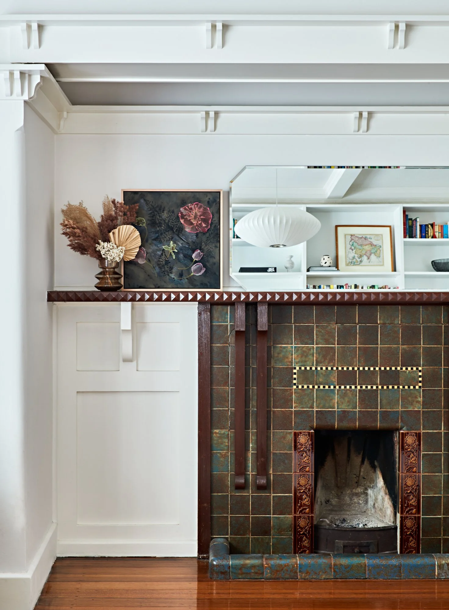 Original tiled fireplace with retained wall and ceiling detailing at Adella Court, Elwood.
