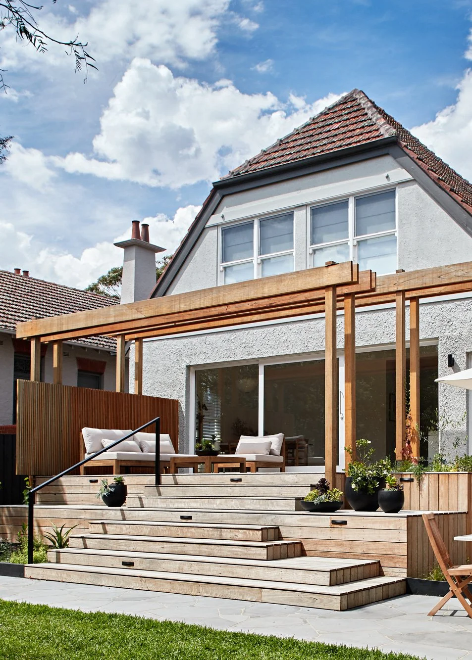 Rear extension of Adella Court, Elwood with timber deck, pergola and steps connecting the home to the garden.