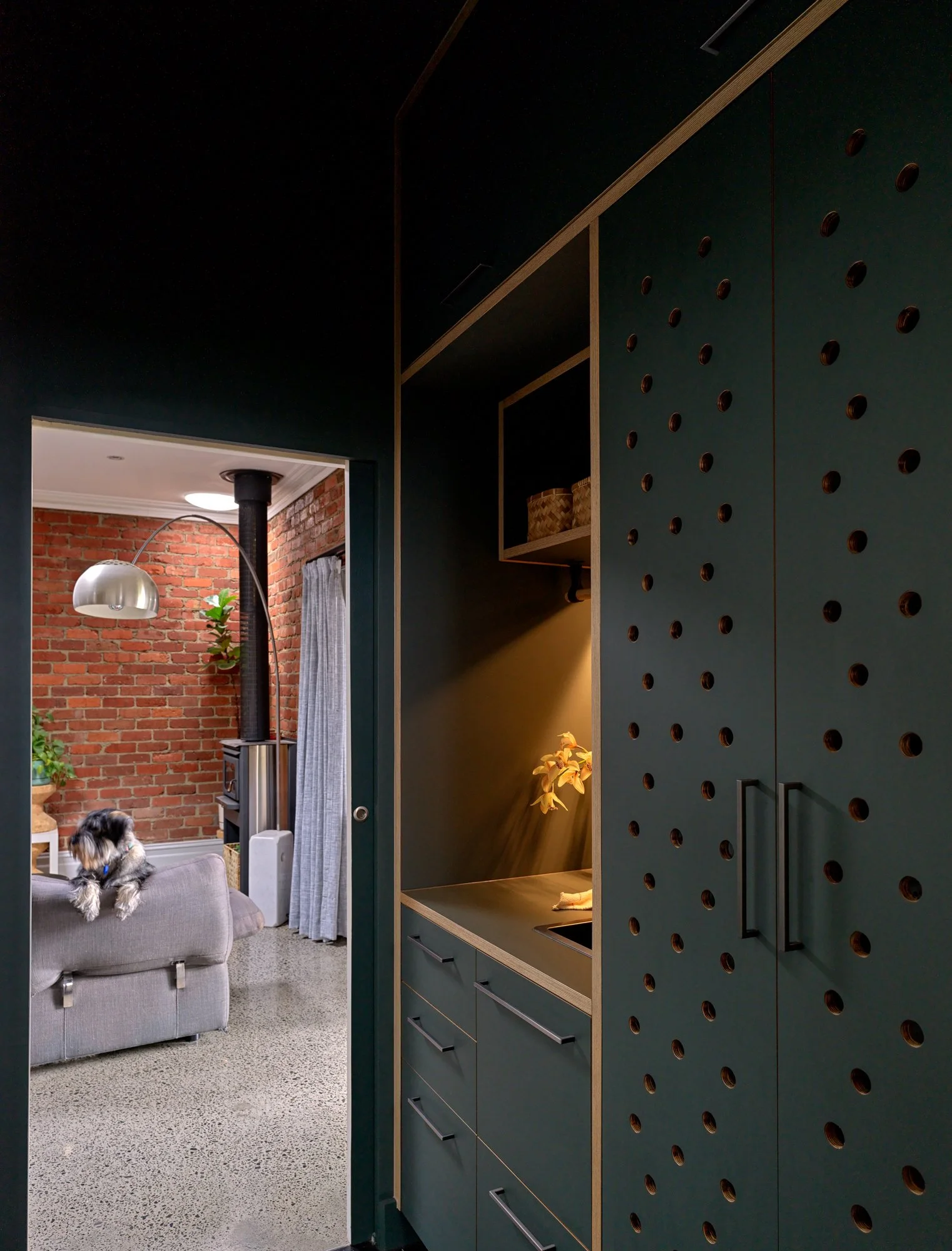 View of Brunswick Laundry and its deep green cabinetry from the adjoining living area.
