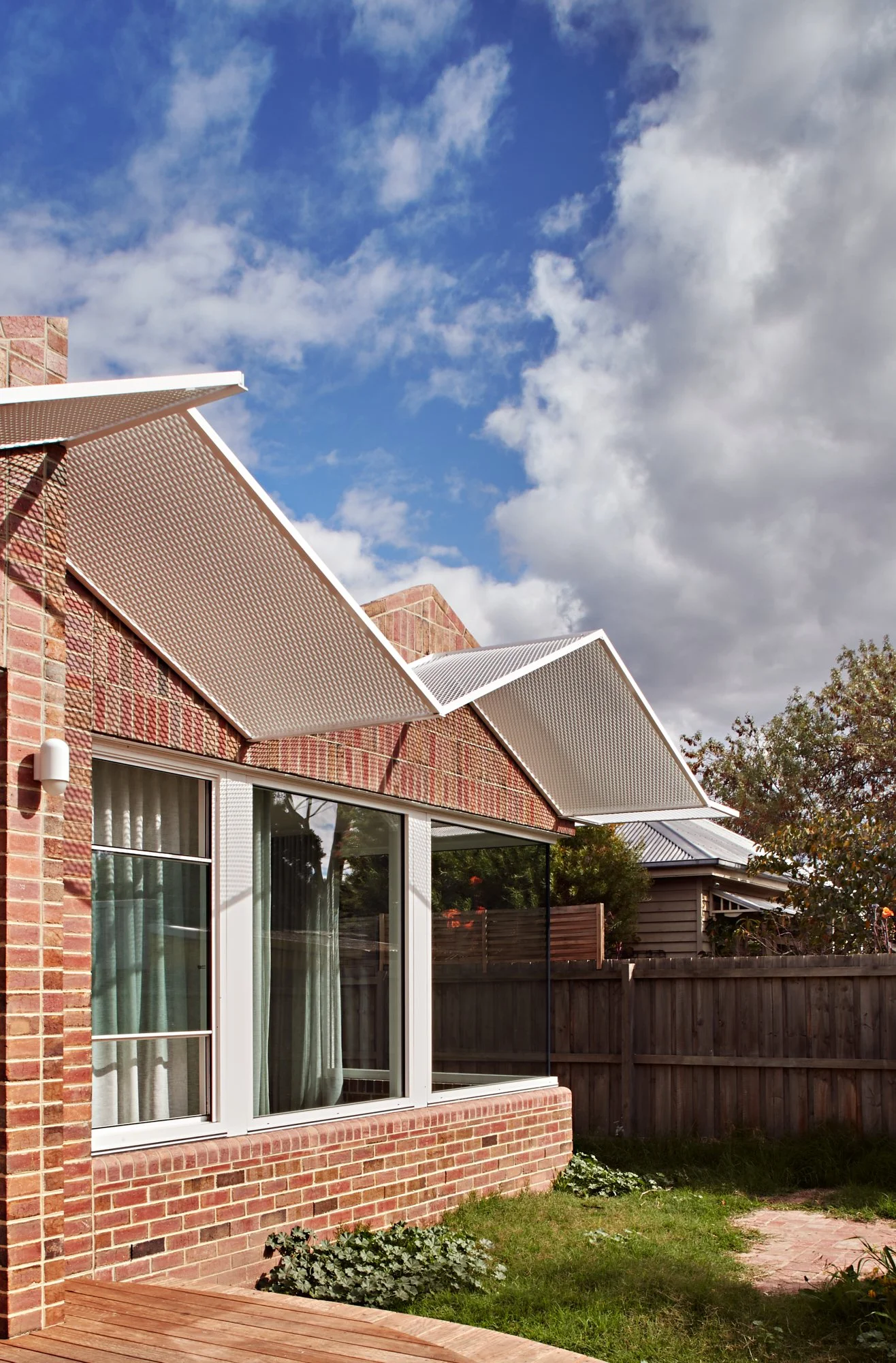 Exterior view of Northcote Green House showing the brick facade, windows and projecting perforated roof screens.
