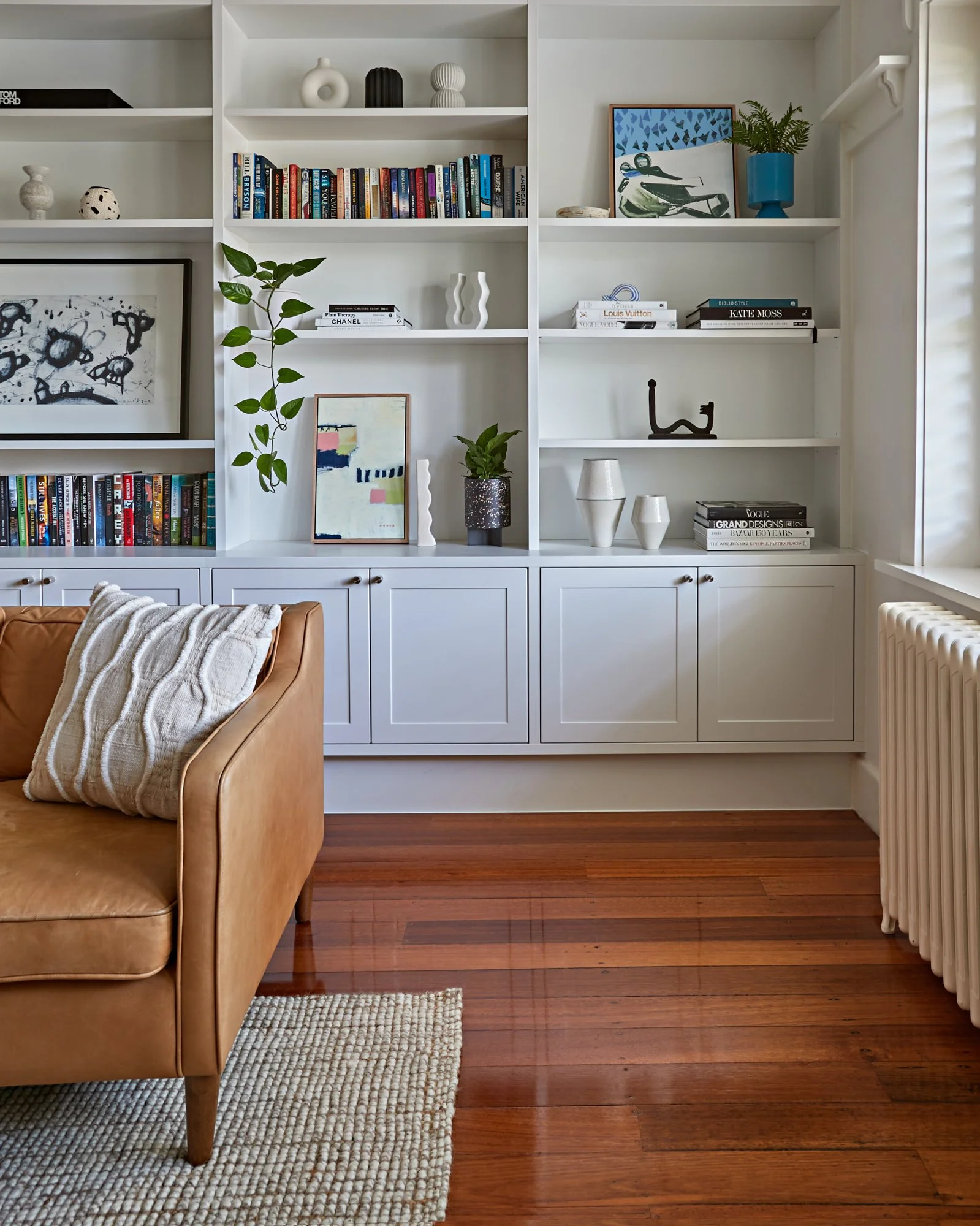 Custom living room shelving and cabinetry beside the original radiator at Adella Court, Elwood.