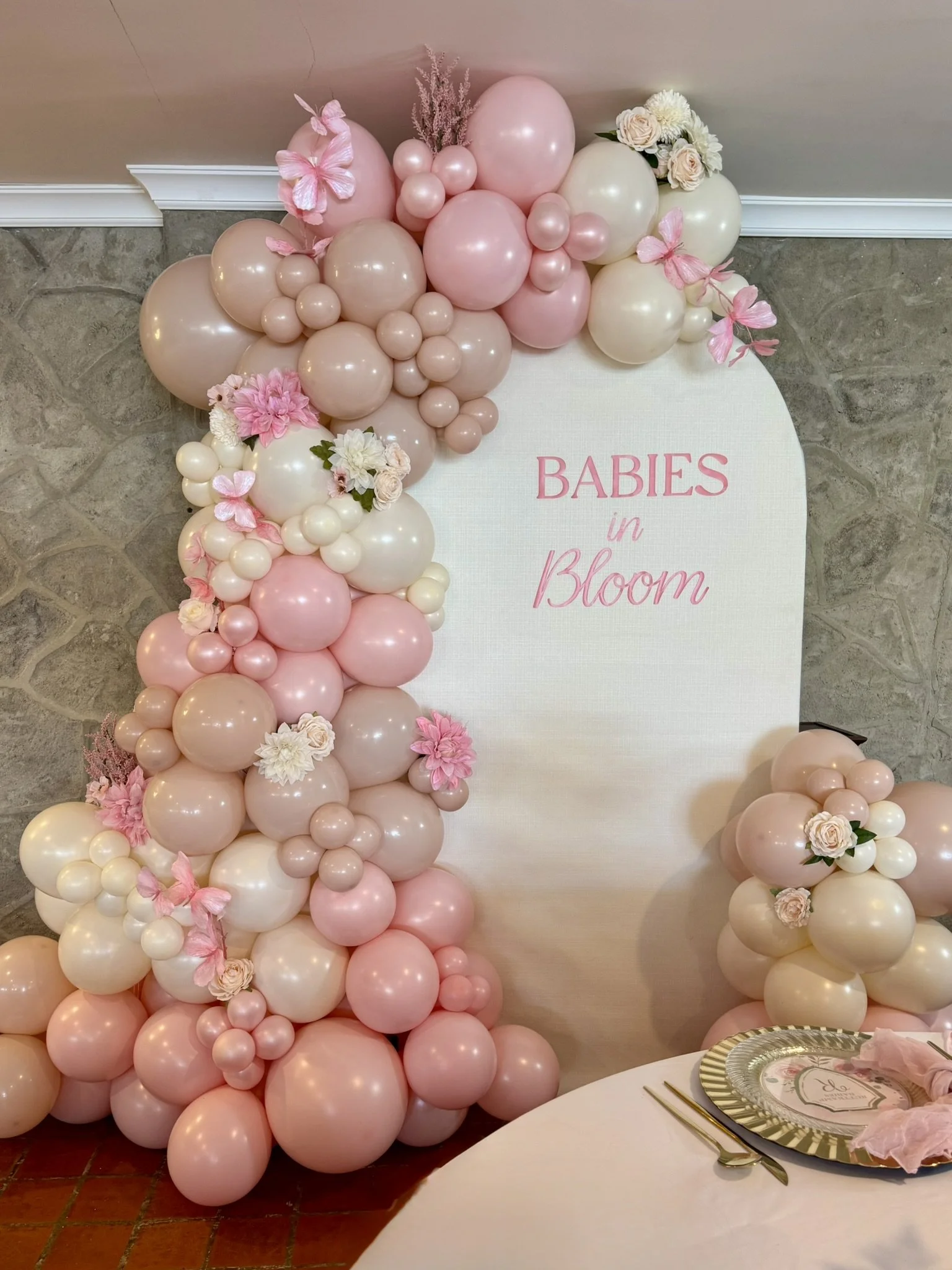 Baby in Bloom pink, cream and tan balloons decorated with butterflies and flowers.