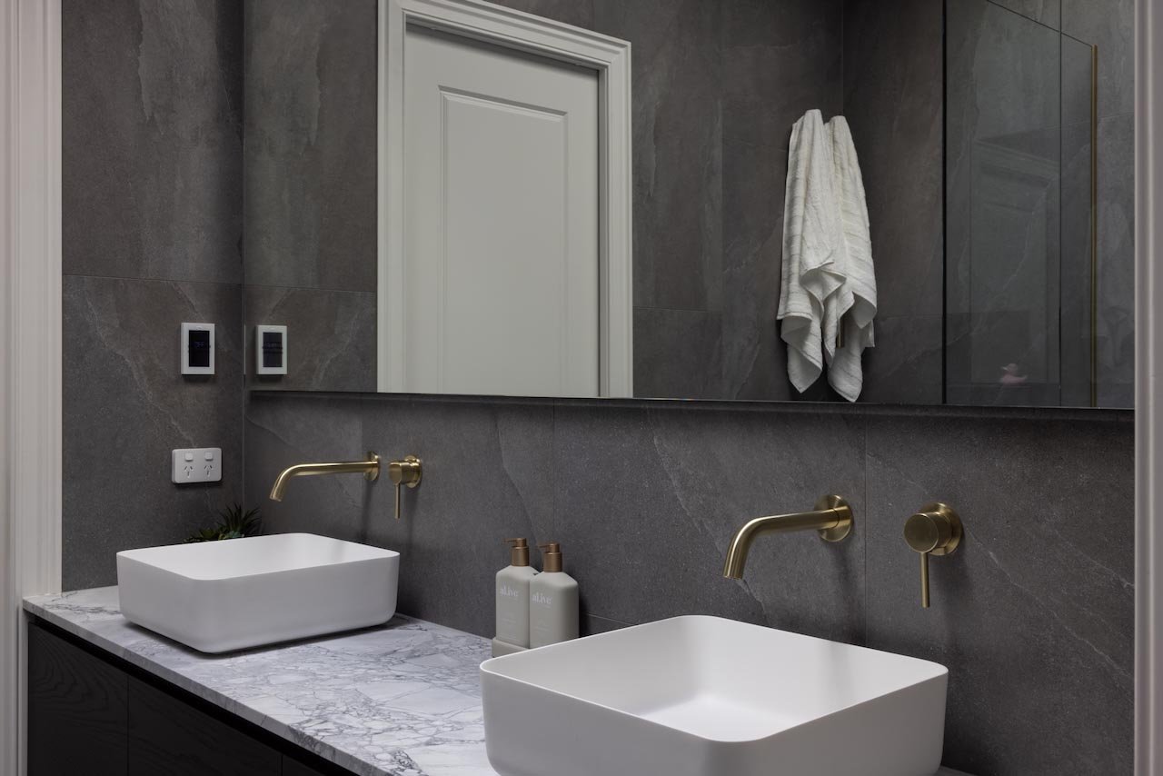 Double vanity with white sqaure basons and brass tapware.
