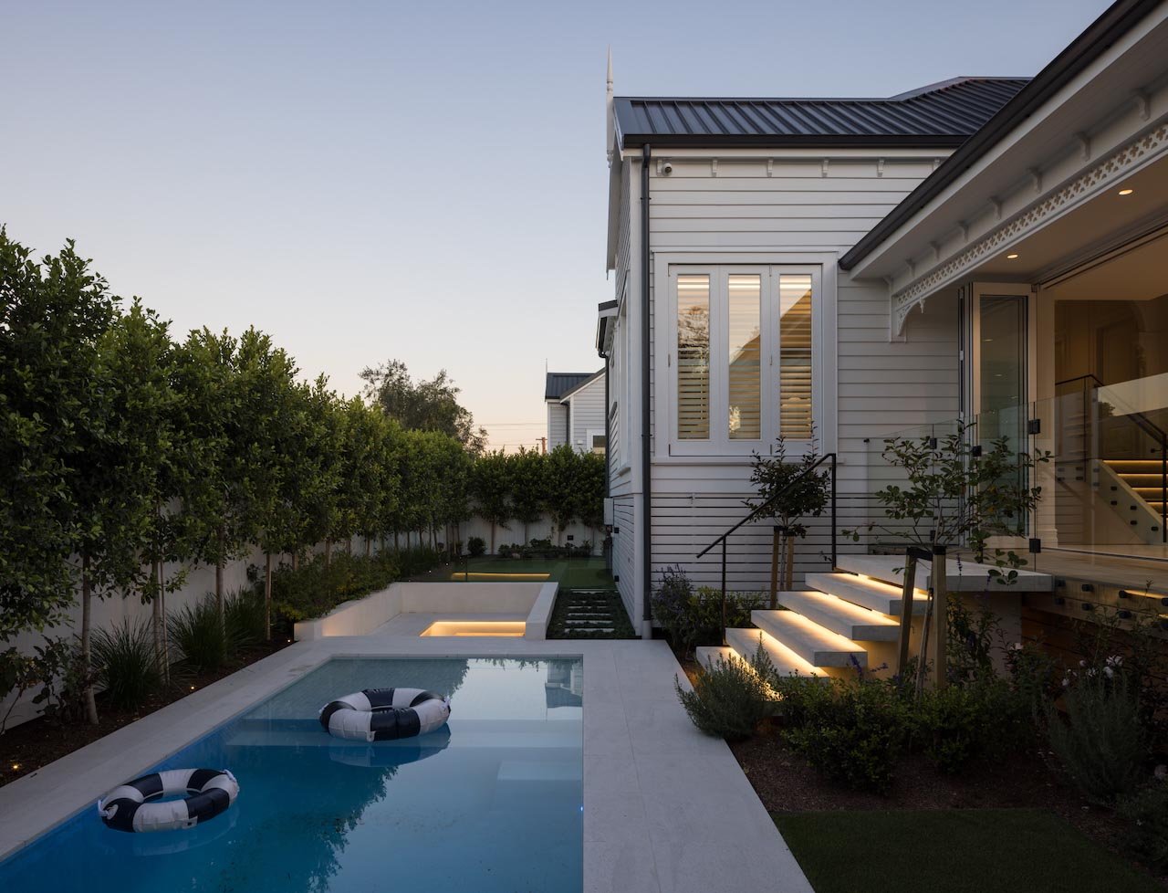 Exterior of a villa with landscaped grouns and a swimming pool.