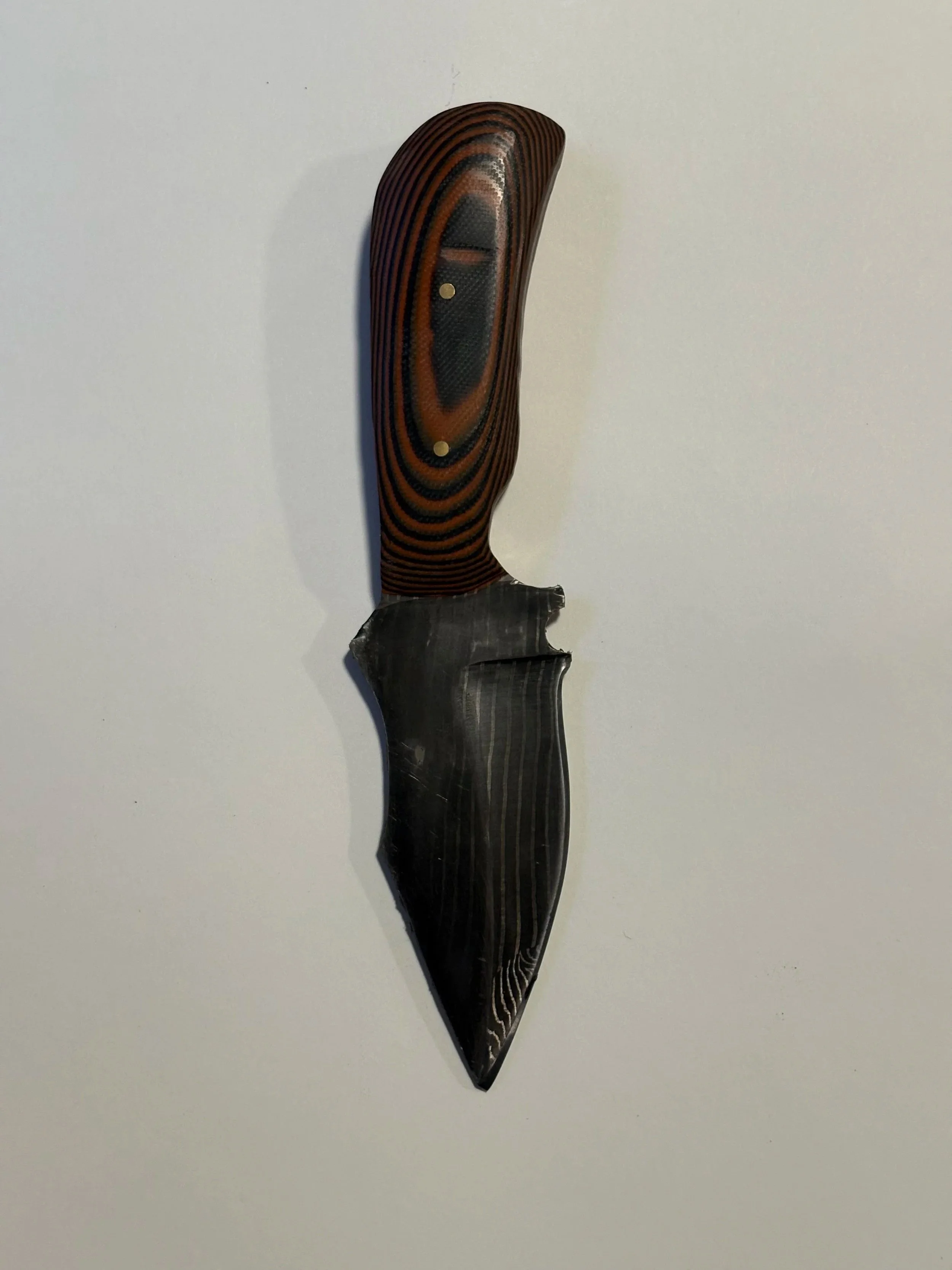 A fixed-blade knife with a black and gray striped handle and a partially serrated black and gray blade on a white background.