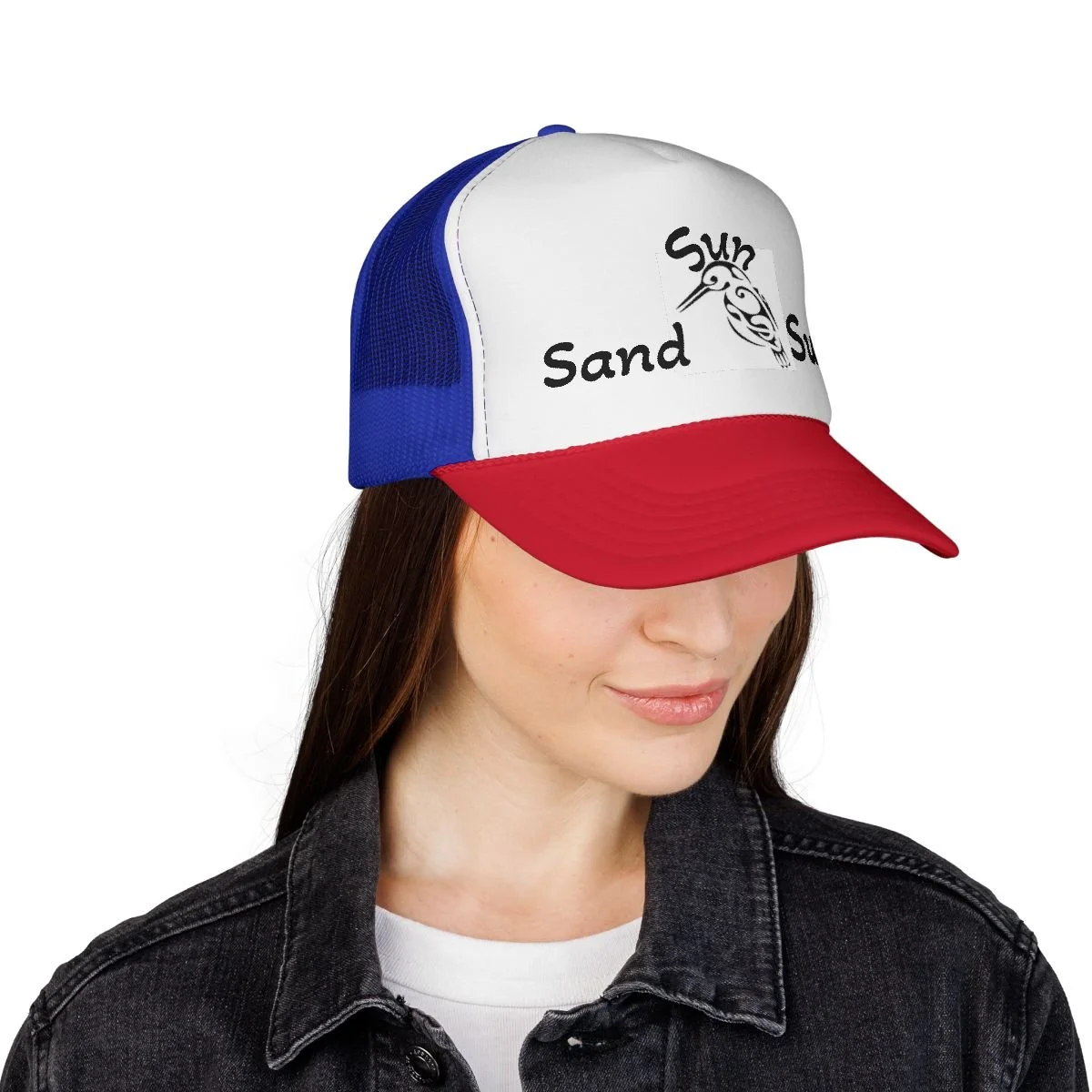 A woman is wearing a trucker hat with a red brim, white front panel, and blue mesh back. The front panel has a graphic of a fish and the words 'Sand', 'Sun', and 'Sea'.