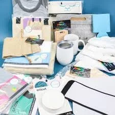 Assorted craft supplies, including fabric, mugs, Cricut accessories, and various packaging materials on a blue background.