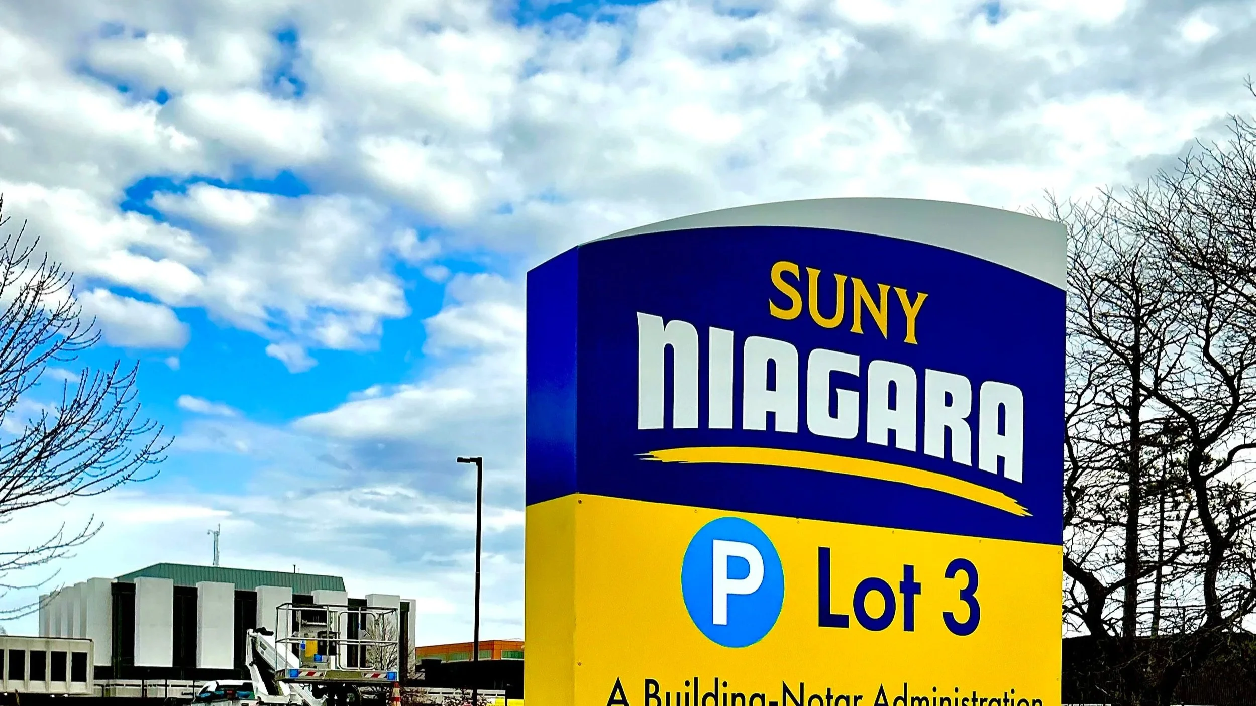 sign for SUNY Haugara, parking lot 3, with a blue sky and clouds in the background.