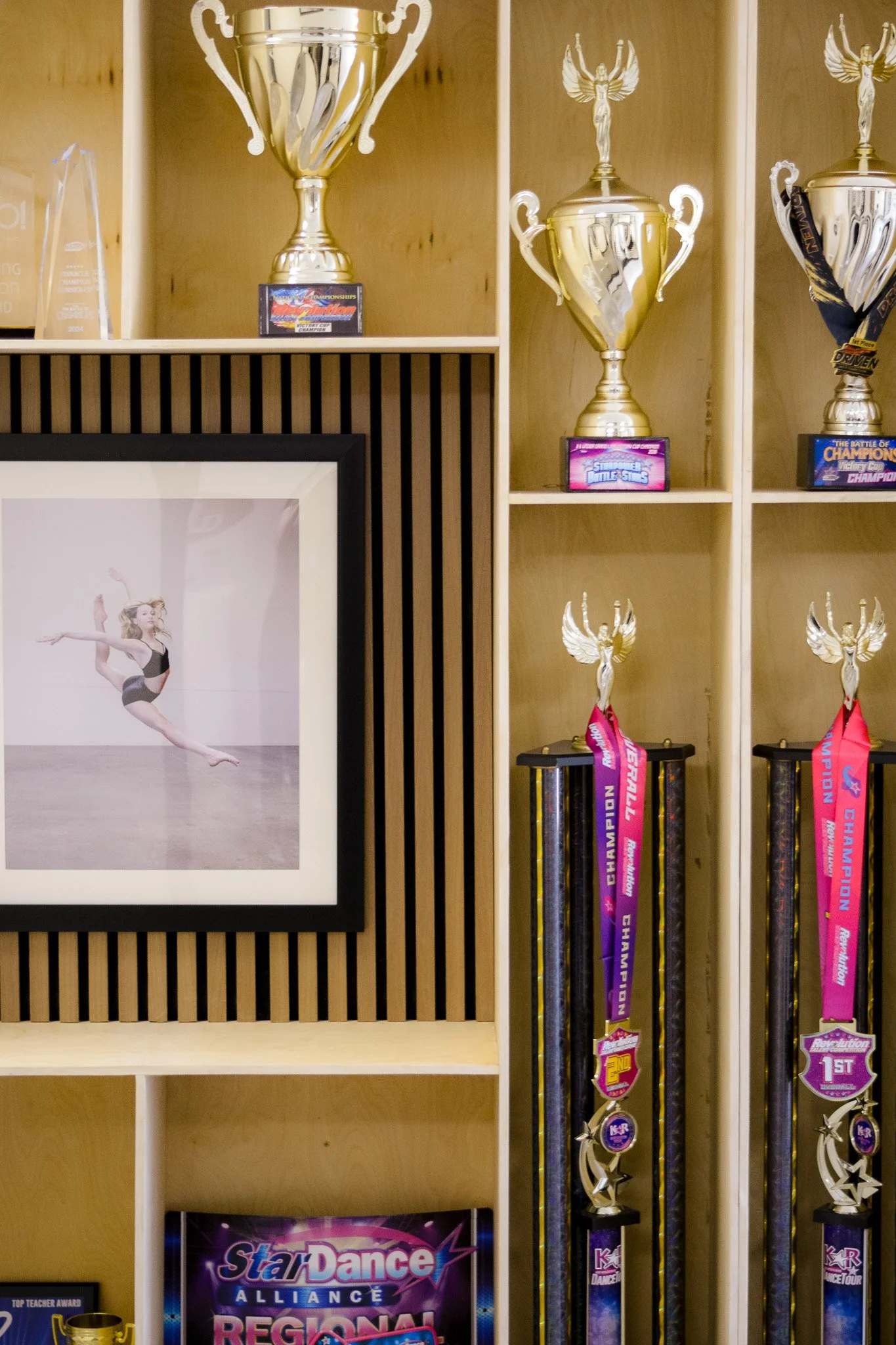 Wooden display shelves with first place trophies, awards, in a Competitive dance studio in Brea and Fullerton