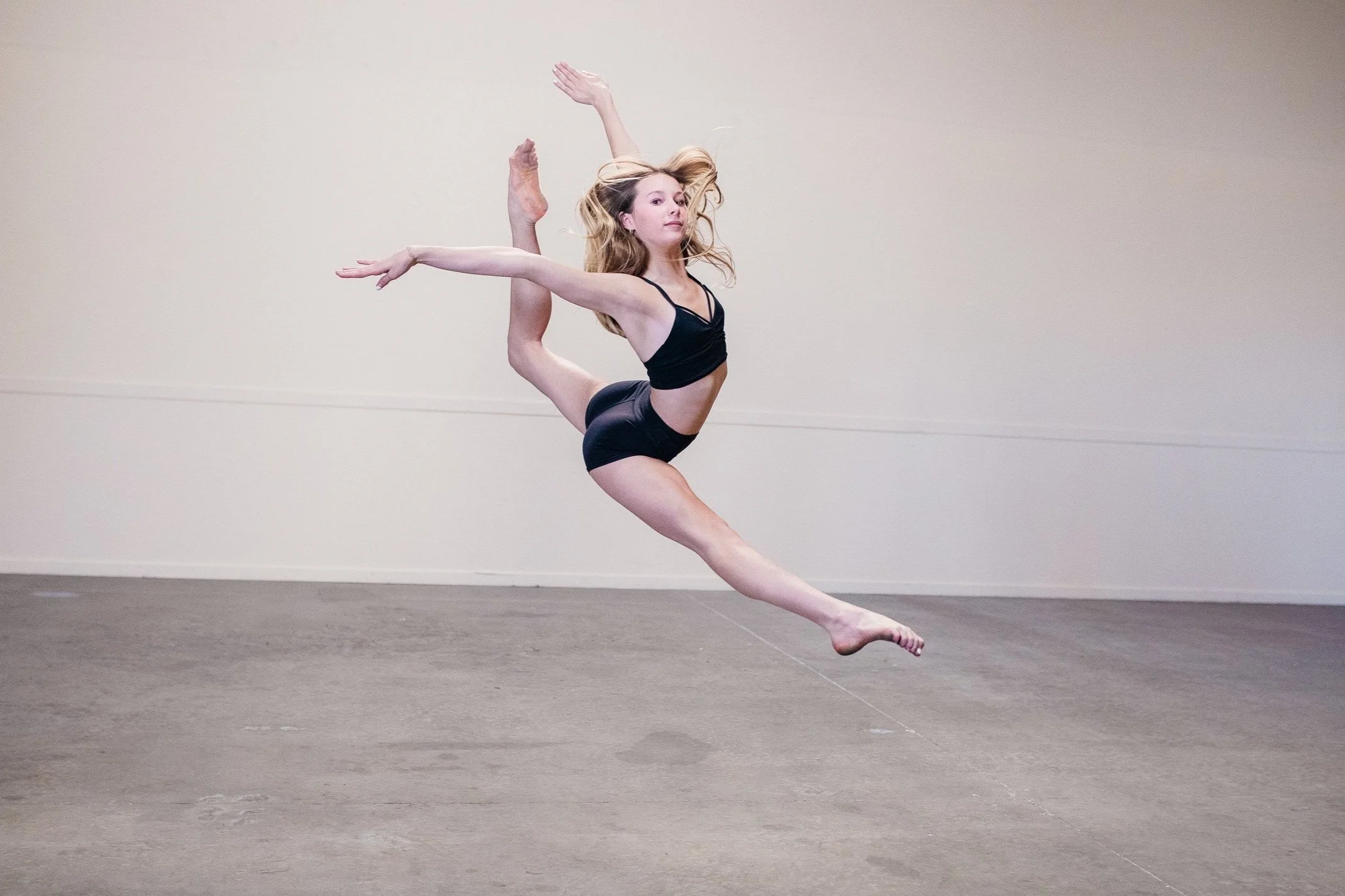 High school dancer doing a leap in black in dance photography poses-Studio-J-Dance-Collective-brea-fullerton-ballet-competition-team-dance-studio