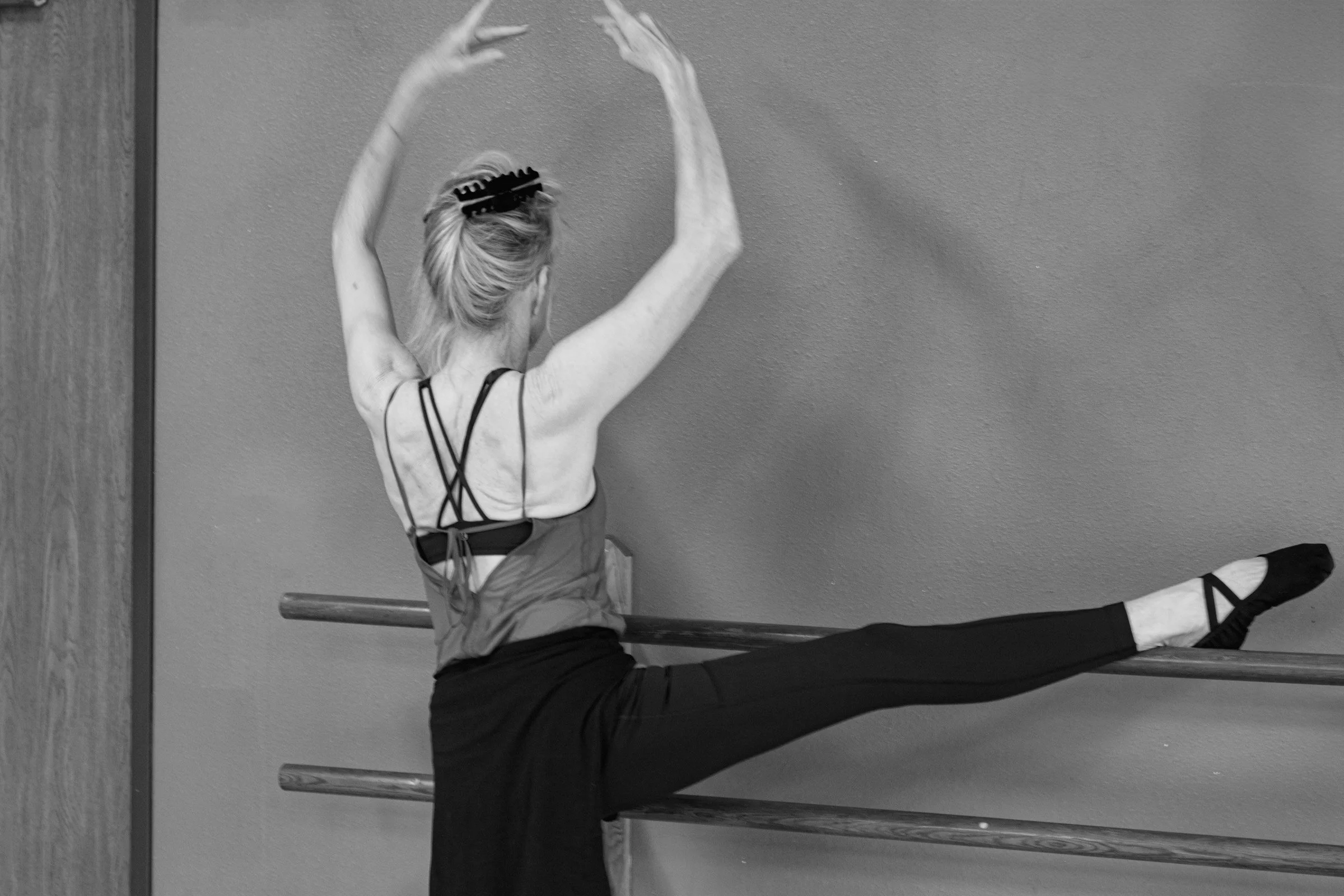 An adult woman in an adult Ballet class stretching at the barre at a dance studio-Studio-J-Dance-Collective-brea-fullerton-ballet-competition-team-dance-studio