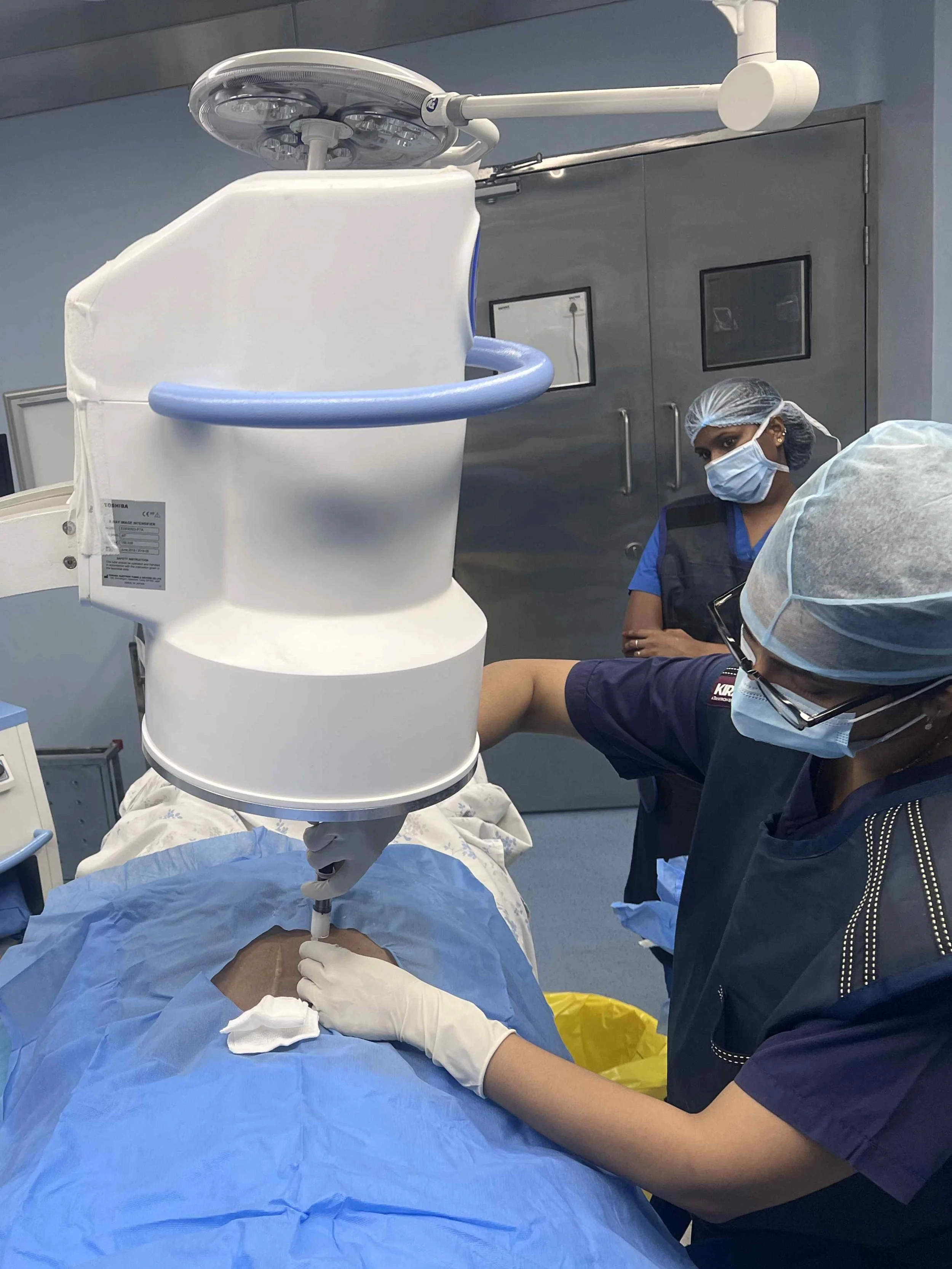 Person in black scrubs standing with hands in pockets