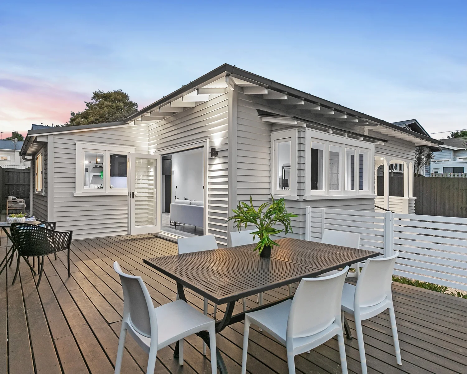 Repainted bungalow exterior with deck at dusk, Mt Albert Auckland