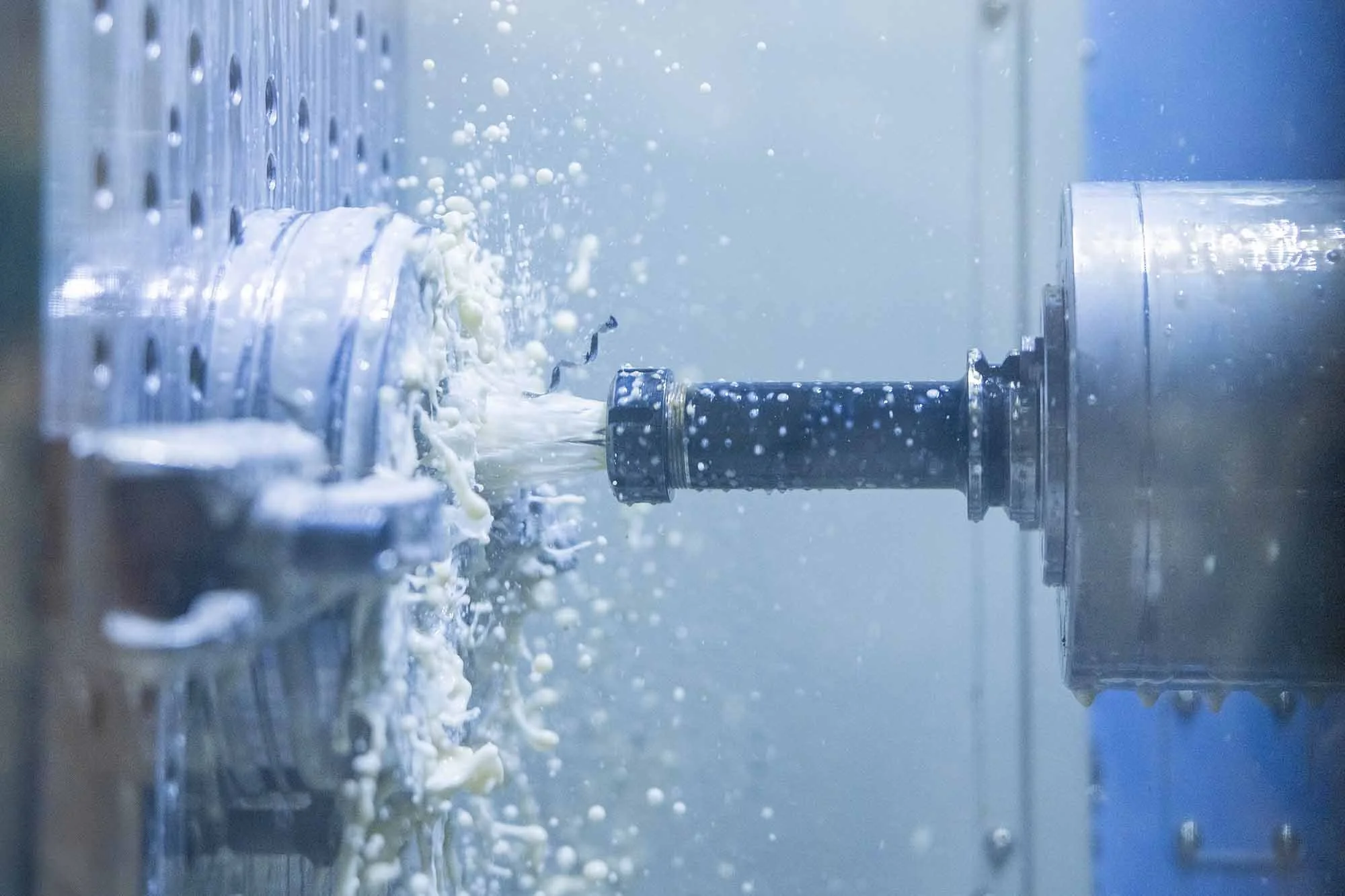 A close-up of a metal pipe with foam and bubbles, likely in an industrial or manufacturing setting.