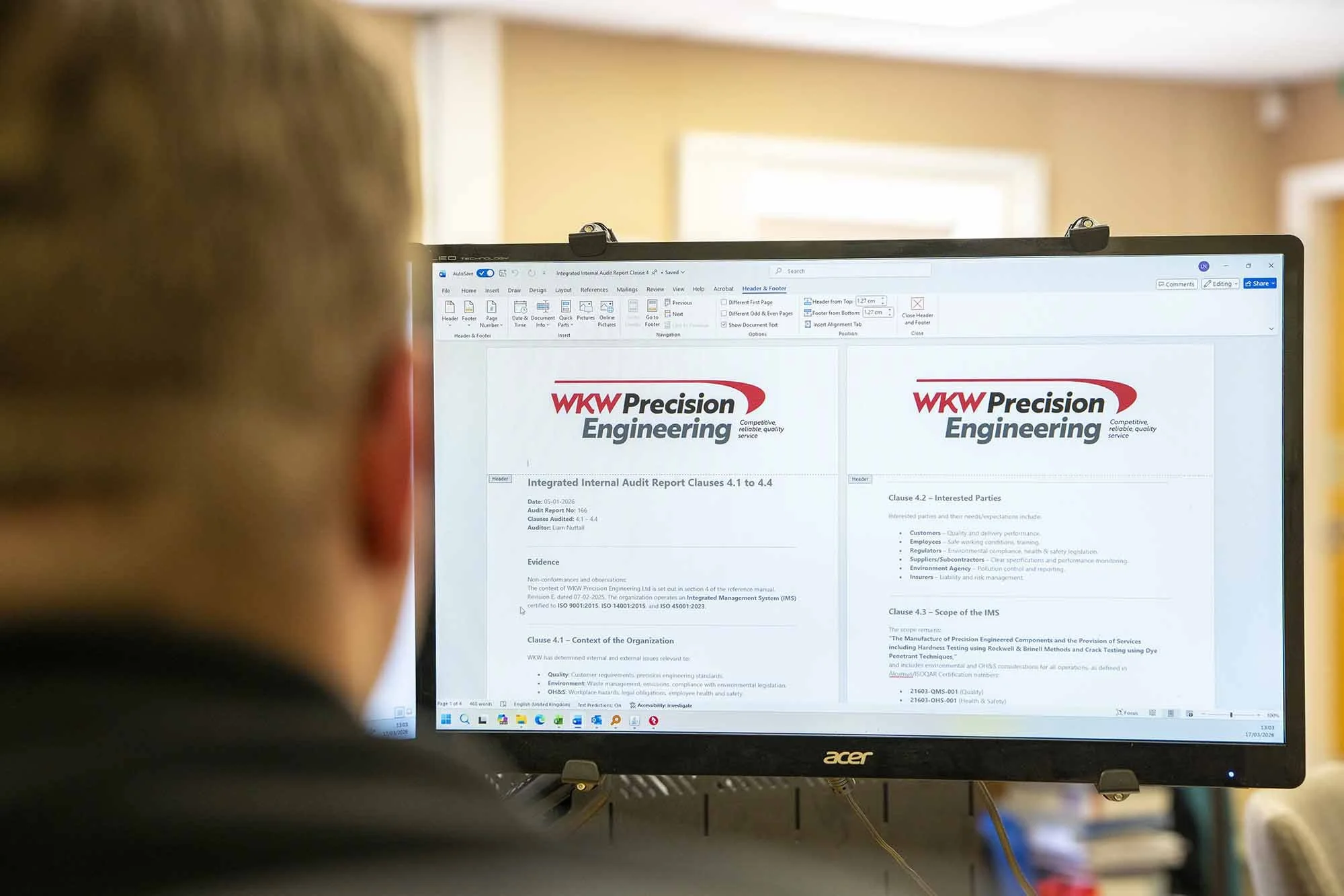 Person viewing a computer screen displaying a document titled 'Integrated Internal Audit Report Clauses 4.1 to 4.4' from WKW Precision Engineering, with the WKW logo visible.