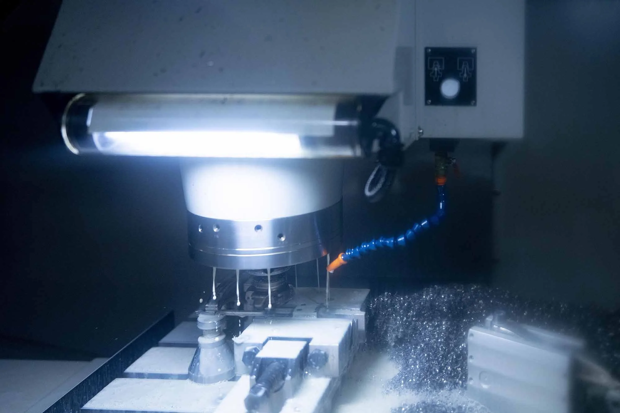 Close-up of a CNC machine cutting metal with coolant spray.