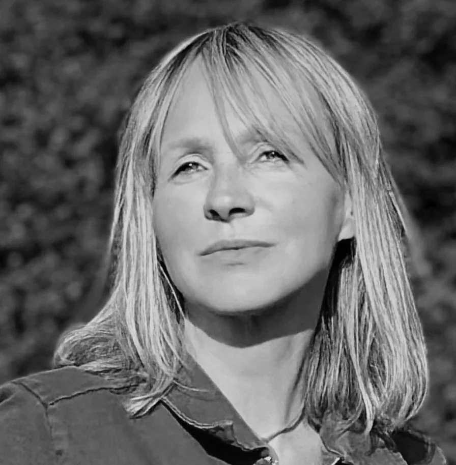 Portrait d'une femme aux cheveux longs et clairs, regardant vers le haut, fond flou.