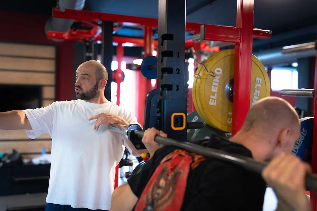 kniebeugen_technik_coaching_mit_klient_im_schwarzen_t_shirt