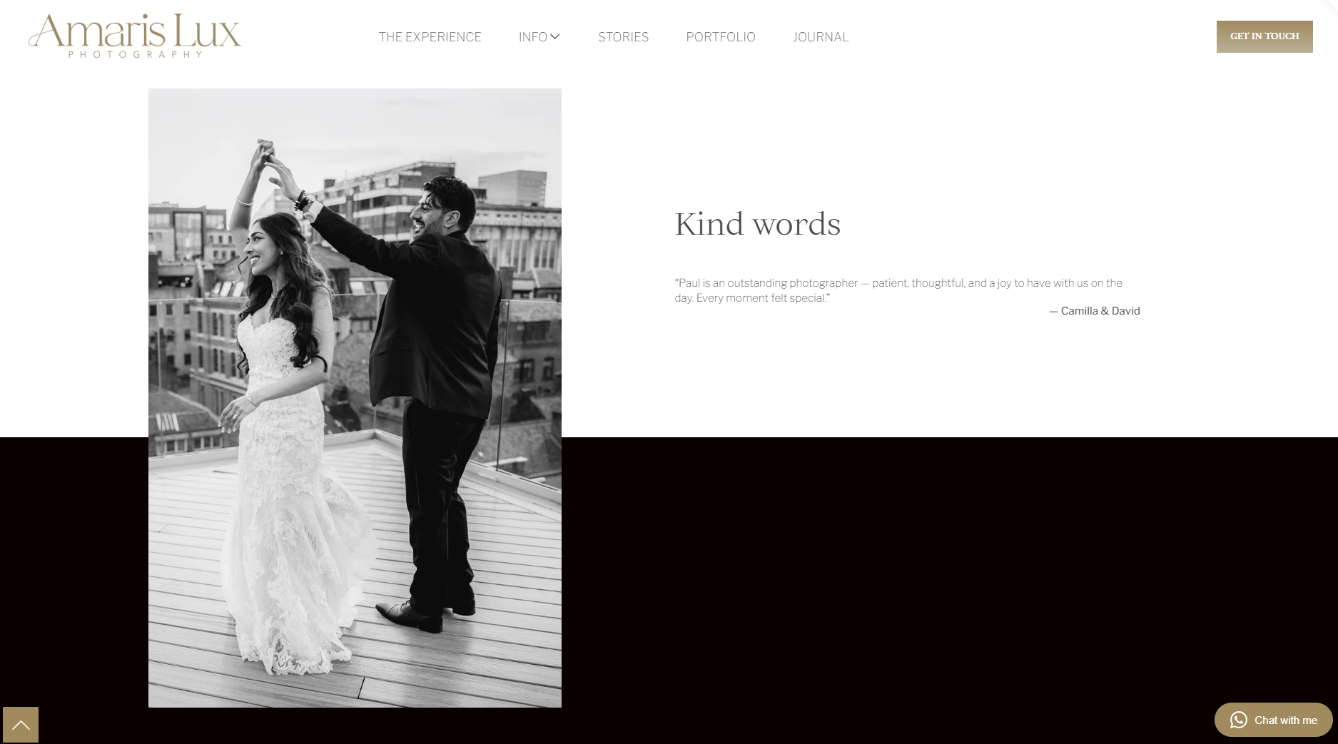 Black and white photo of a bride and groom dancing on a rooftop with city buildings in the background.
