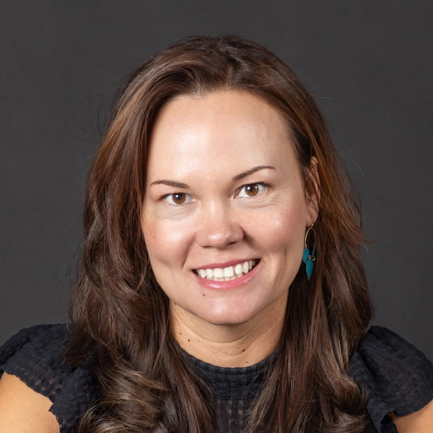 woman smiling, featured in testimonial about The Greater Sum Foundation incubator program