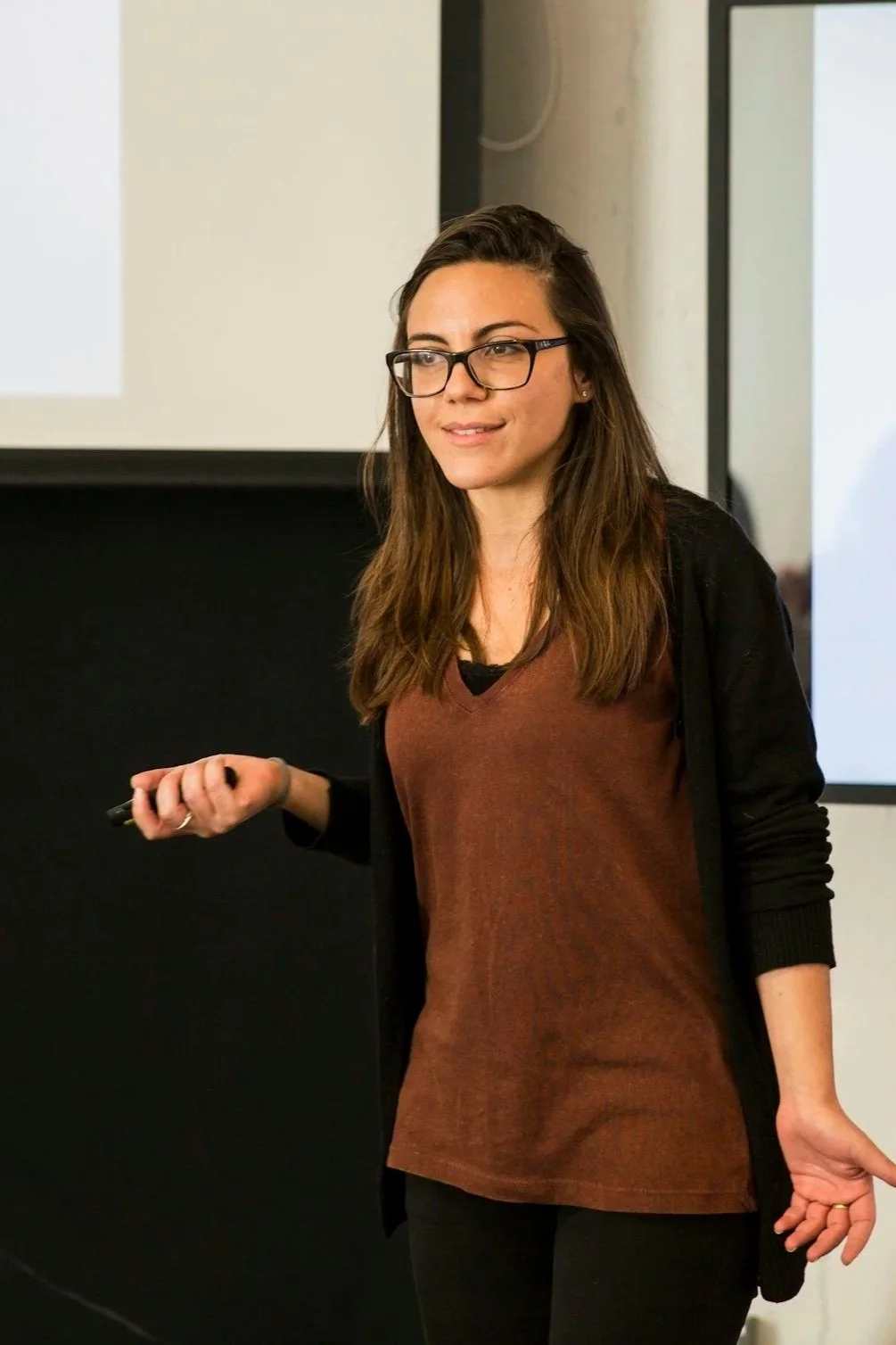 A woman addresses an audience with a clicker in her hand