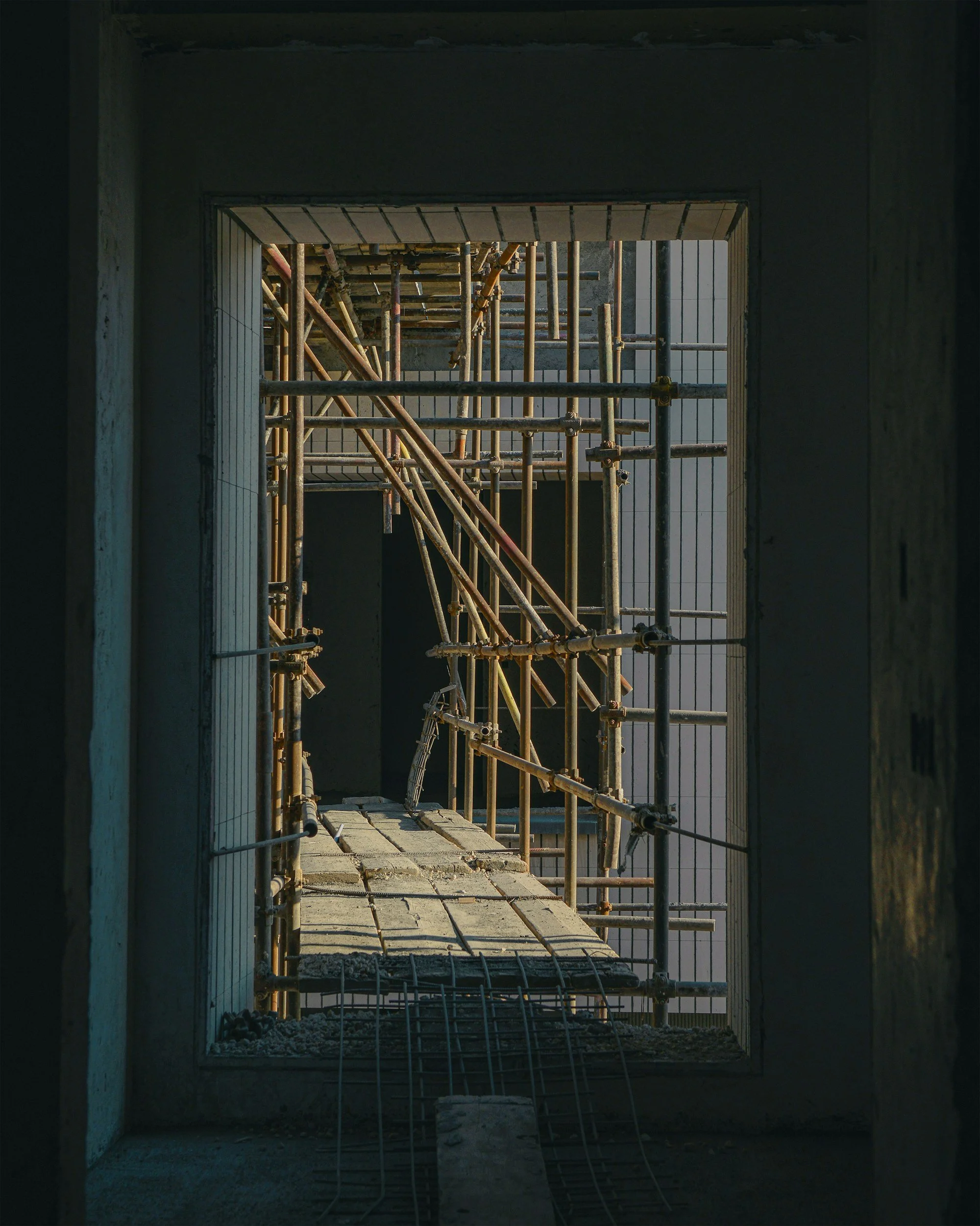 Construction site with metal scaffolding viewed through window opening