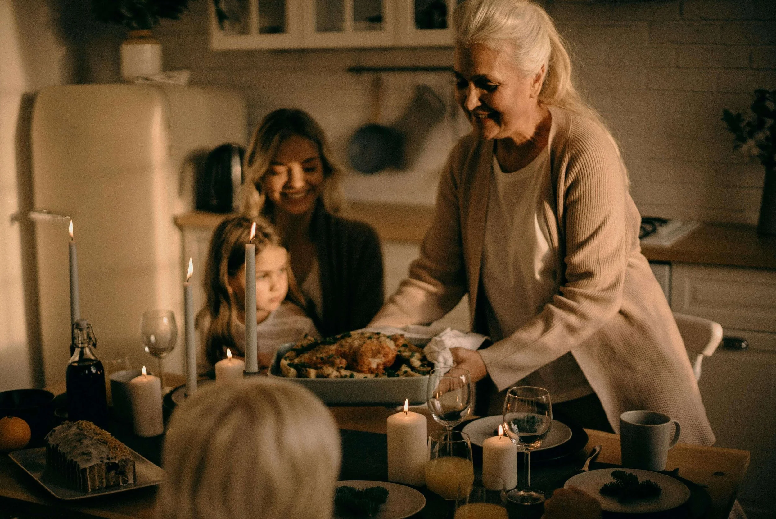 Older woman serving food to her family. Don't rush reconciliation or you'll have to struggle with stress. Find support from a family therapist in New York, NY to overcome the stress beforehand.