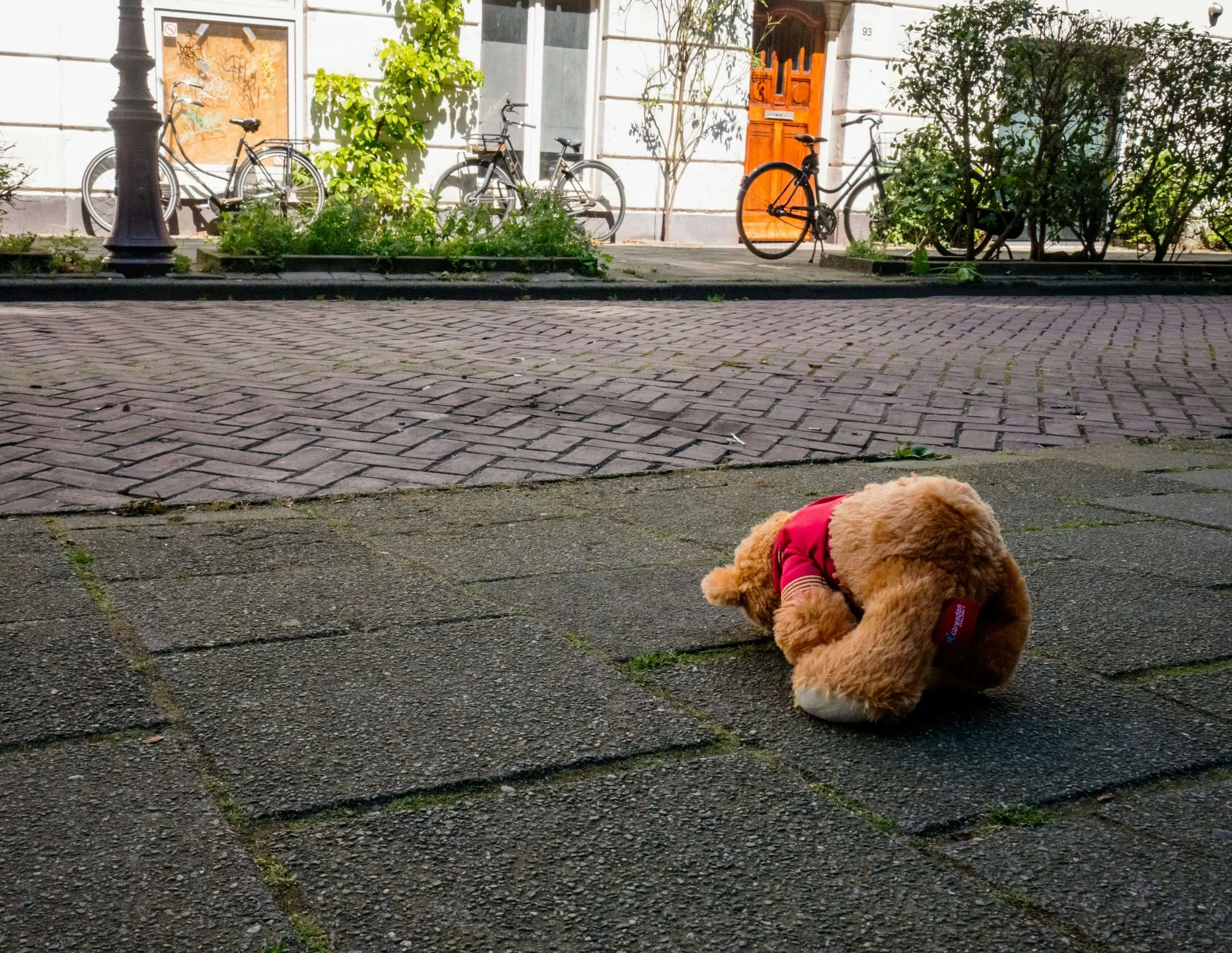Teddy bear laying on a city sidewalk. See your child begin to cope and heal from school based trauma in positive ways with the support of child trauma therapy in New York, NY.