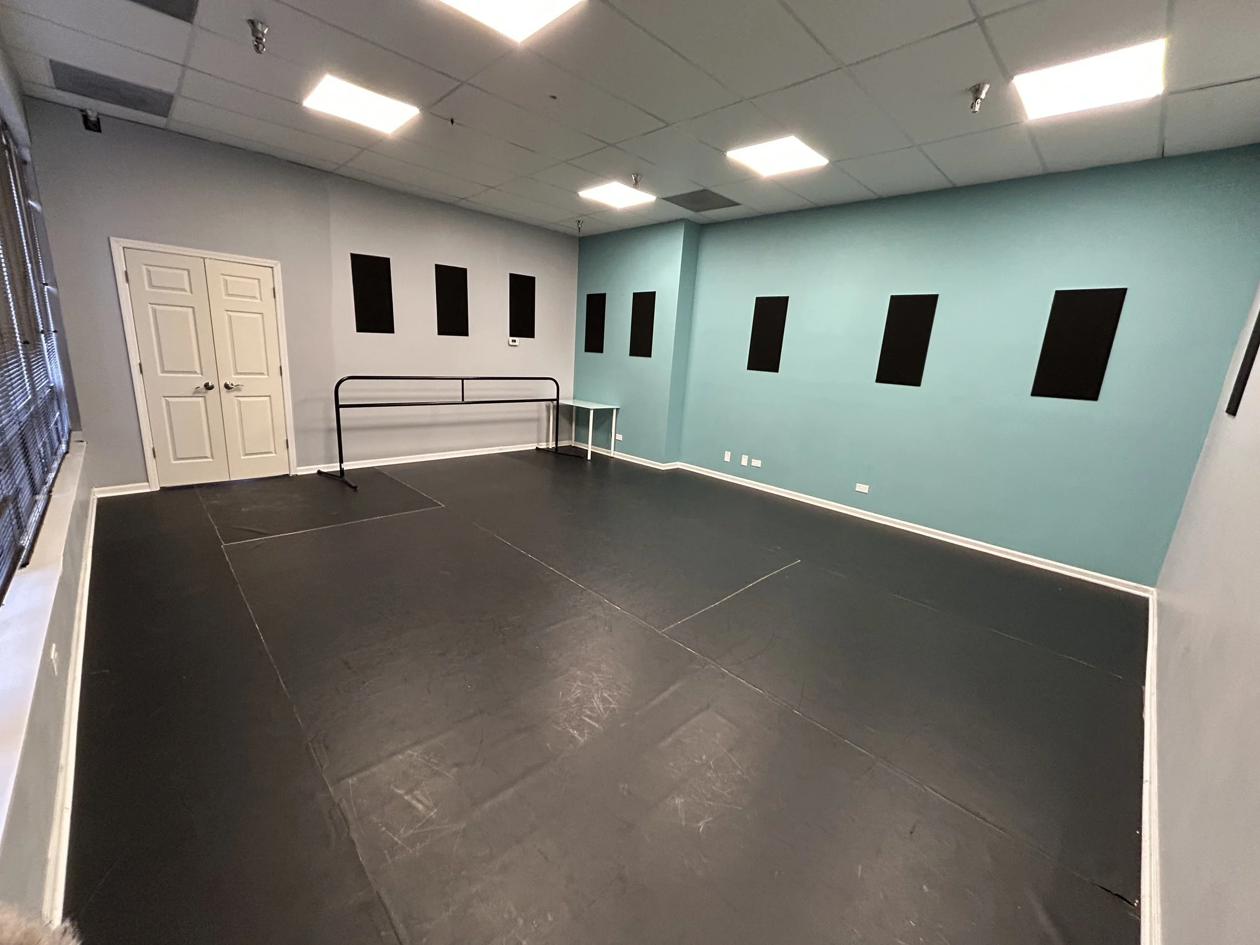 399 sq ft (21’x19’) | black marley floors | portable center barre | one wall of large windows and natural light | stereo system