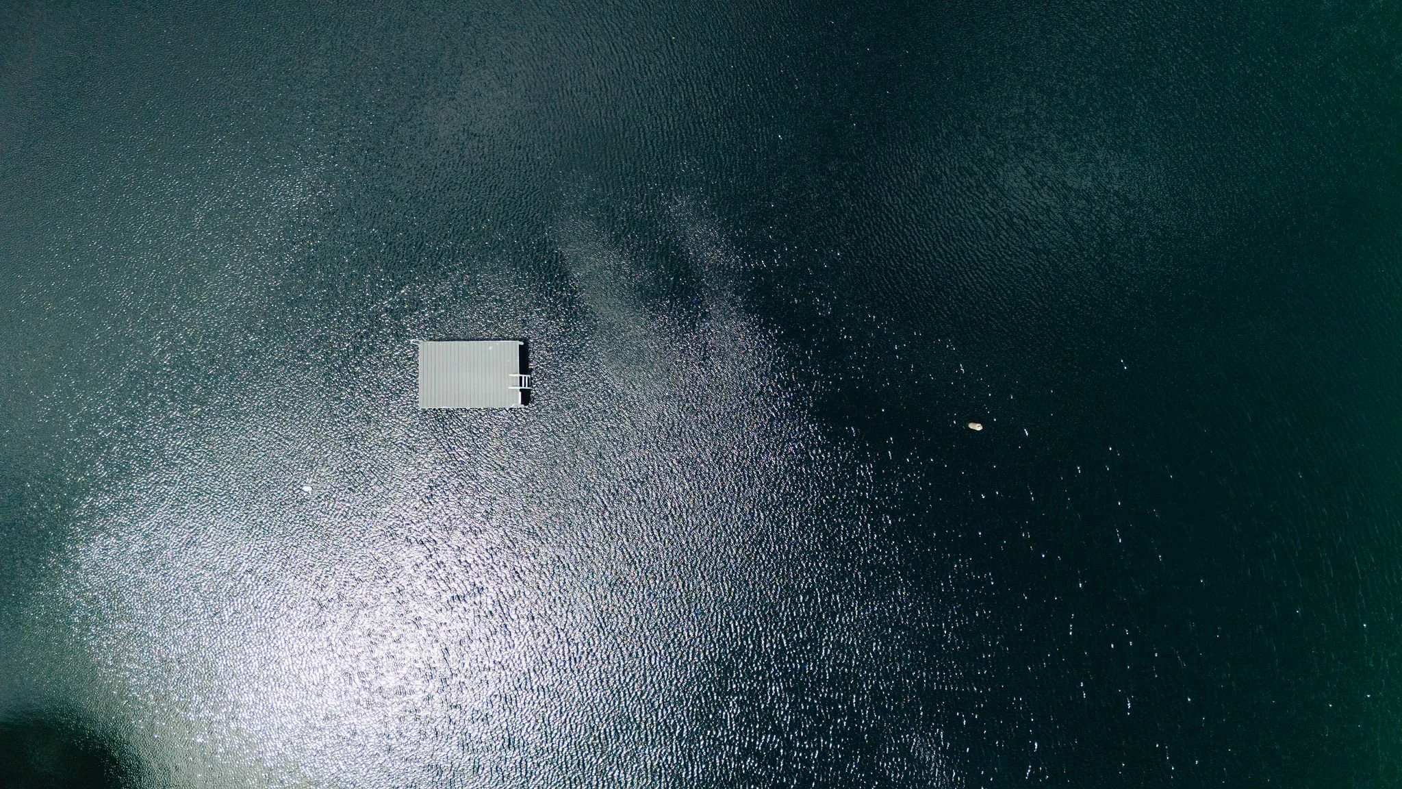 Aerial view of a small boat near a floating dock on a body of water.
