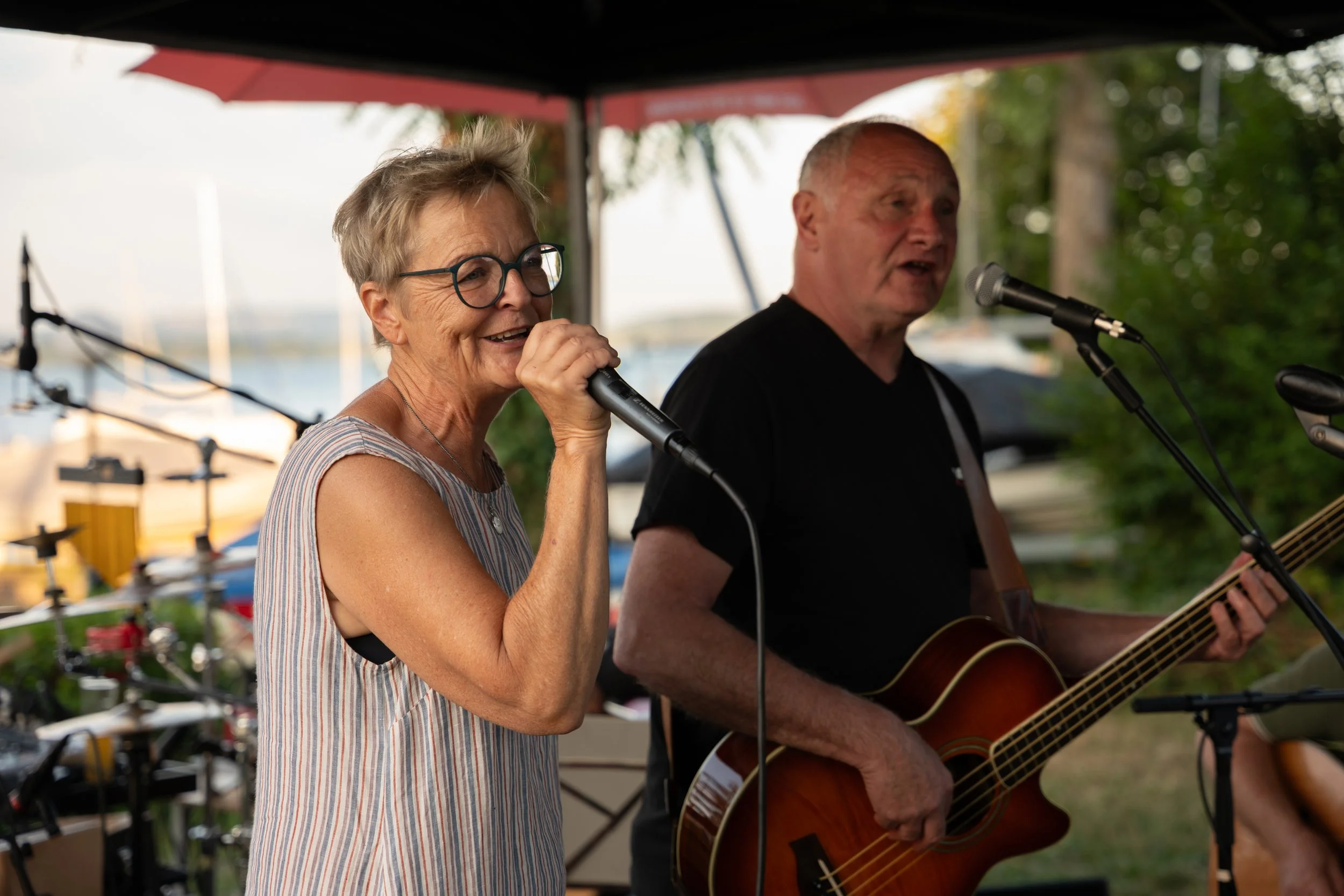 Älteres Paar singt und spielt Gitarre bei einem Open-Air-Konzert im Freien