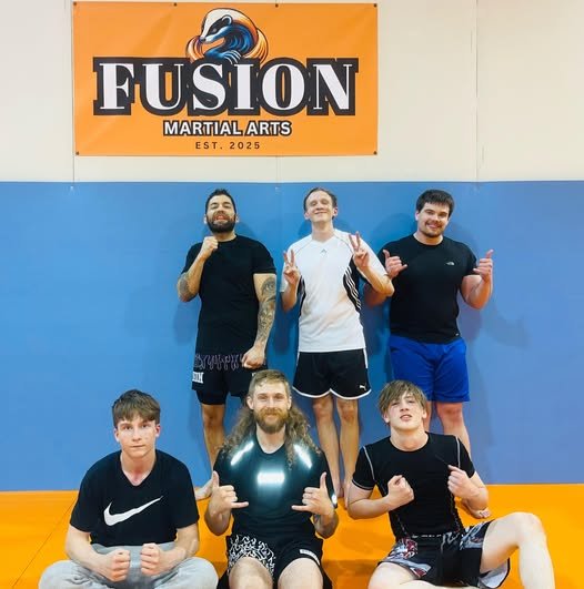 Group of five young men posing in a martial arts gym, with a banner that reads Fusion Martial Arts.