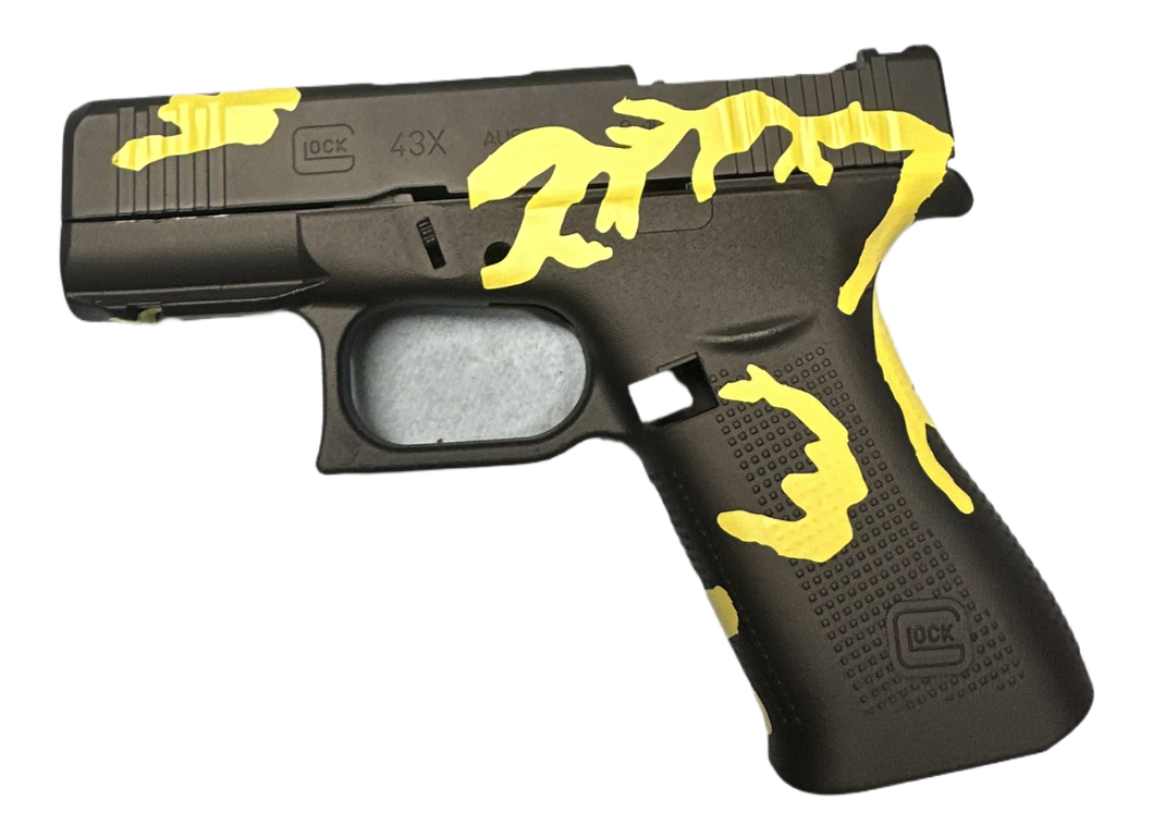 A black Glock pistol with yellow tape or paint marks on it.